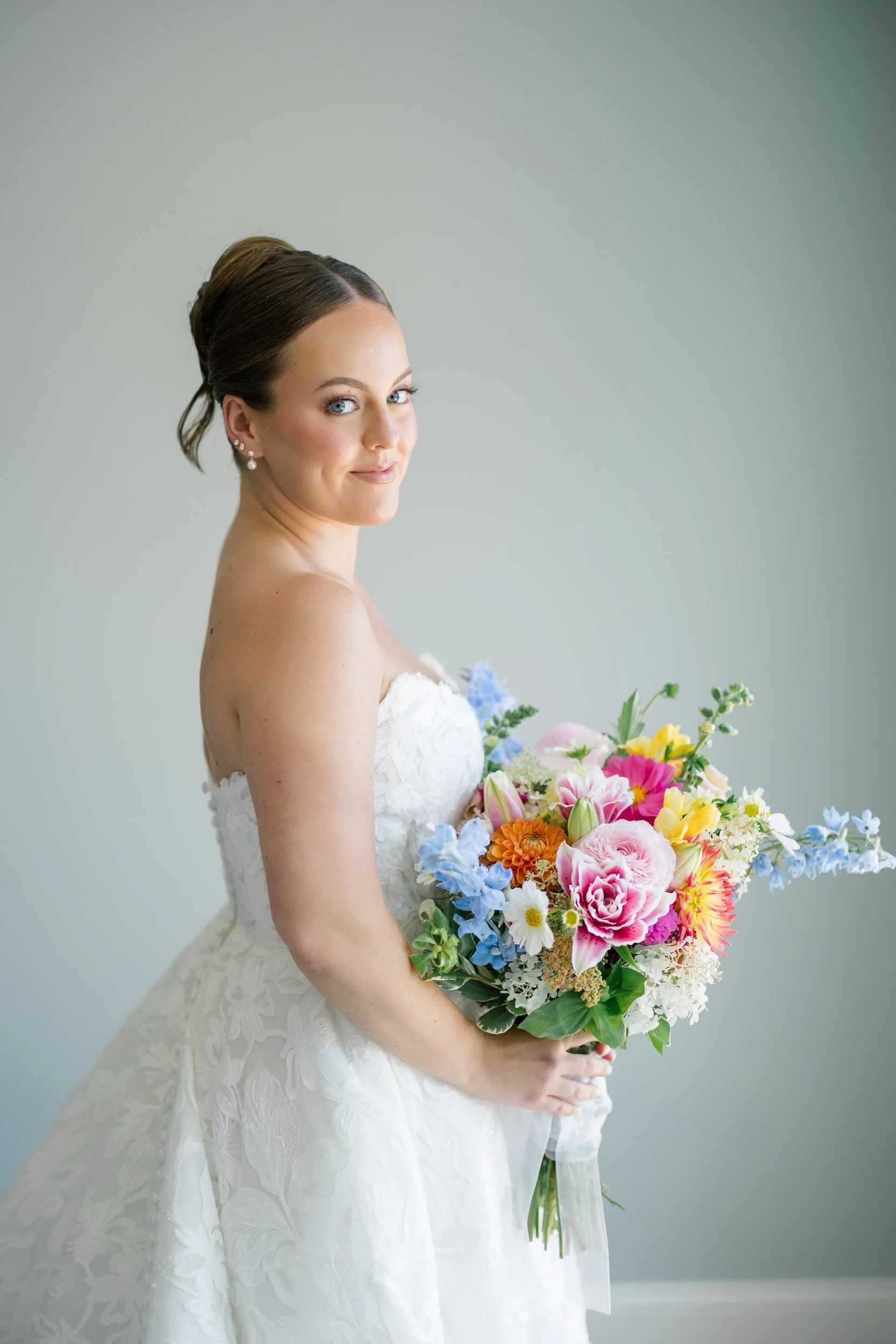 Mother helping the bride into her wedding dress before a Cape Cod waterfront wedding.