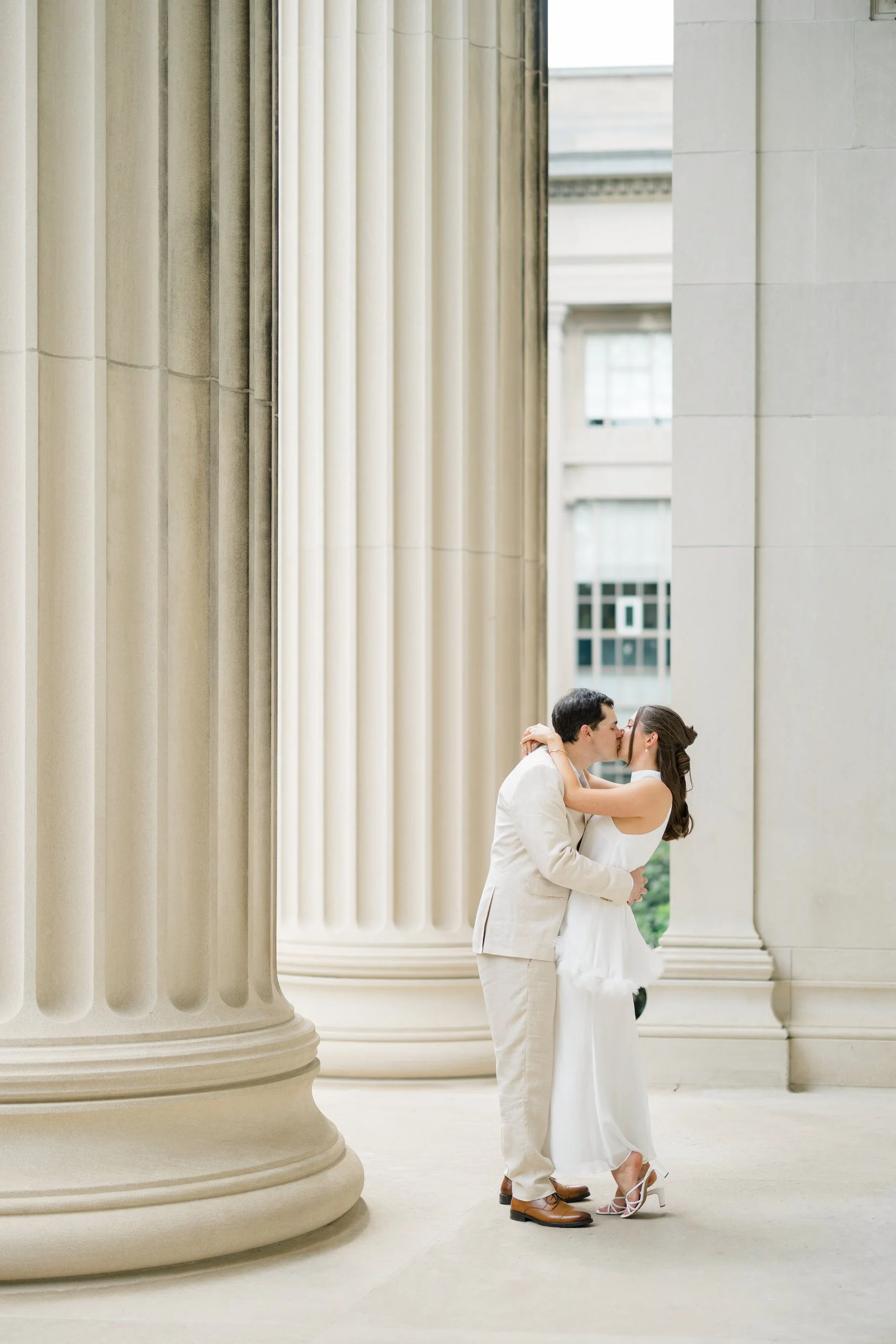 Timeless Cambridge engagement photos surrounded by marble columns and stone architecture.