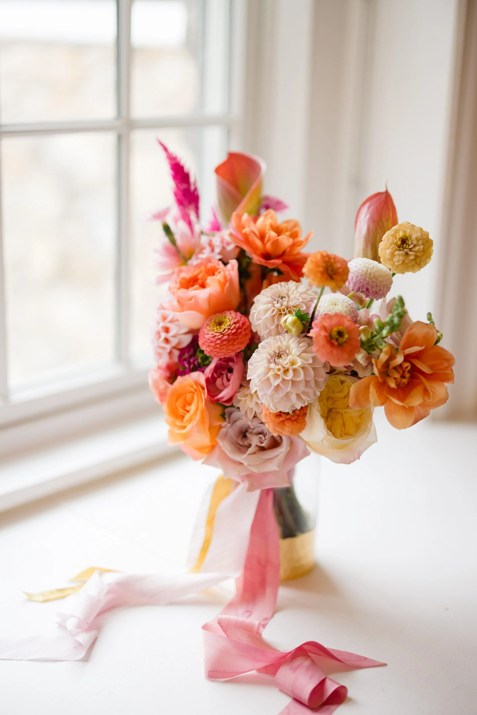 Colorful bridal details featuring vibrant pink, orange, yellow, and red florals at the Connors Center wedding.