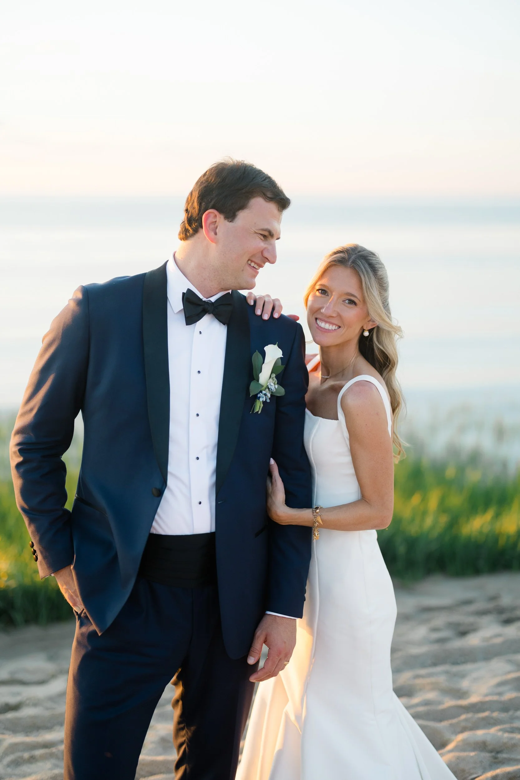 Newlyweds walking along the beach at sunset on Cape Cod