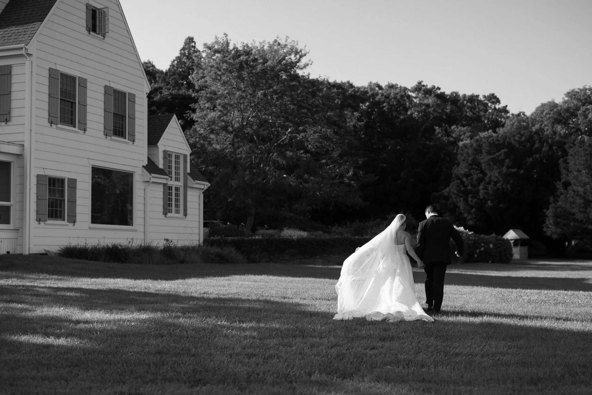 Newlyweds walking along the waterfront at their Cape Cod wedding.