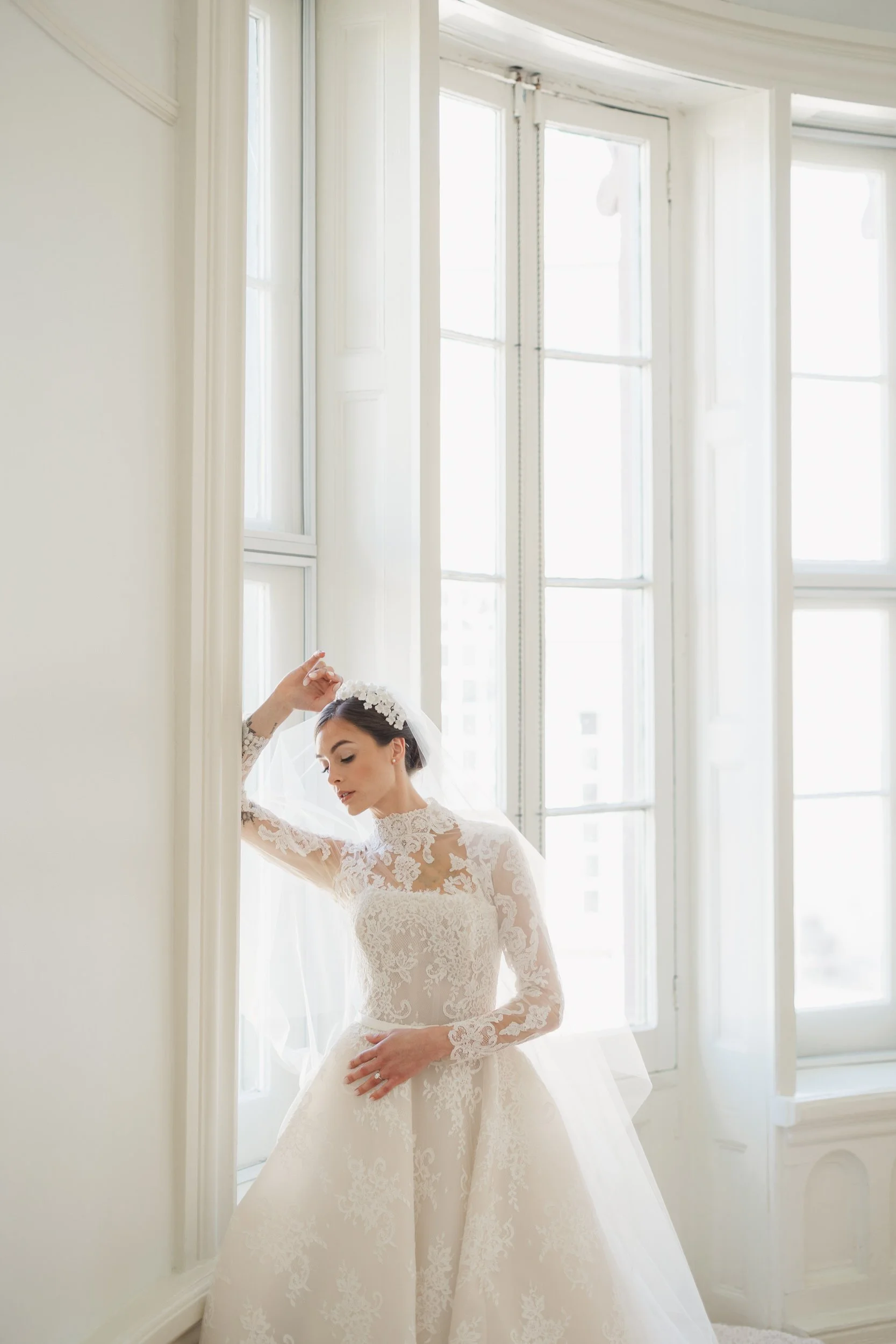 Bride posing inside the grand interior of Brasserie La Banque in Charleston, SC with neutral florals, captured by a Charleston wedding photographer