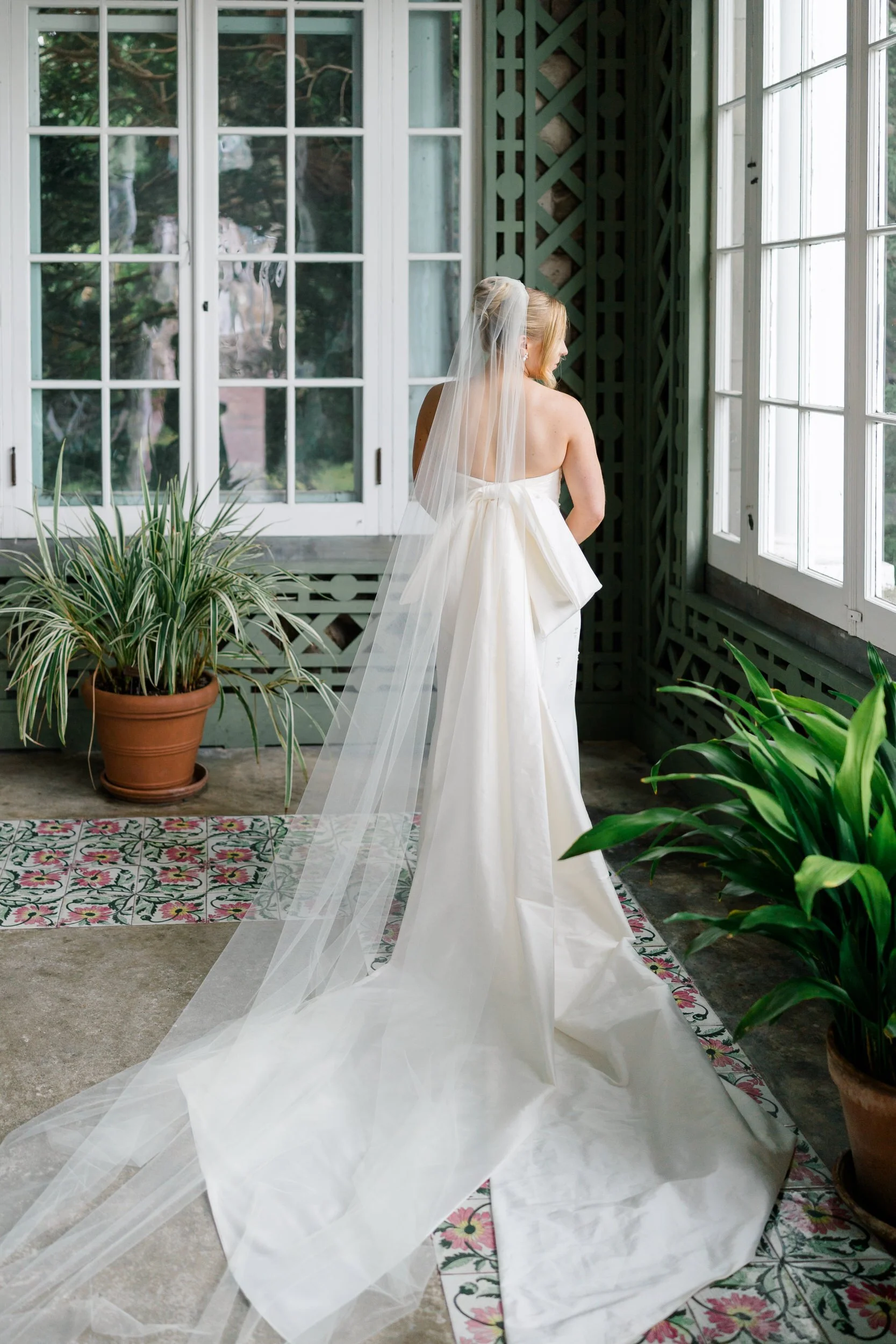 Bride wearing a beaded Watters wedding gown with a cathedral veil at Blithewold Mansion & Gardens.
