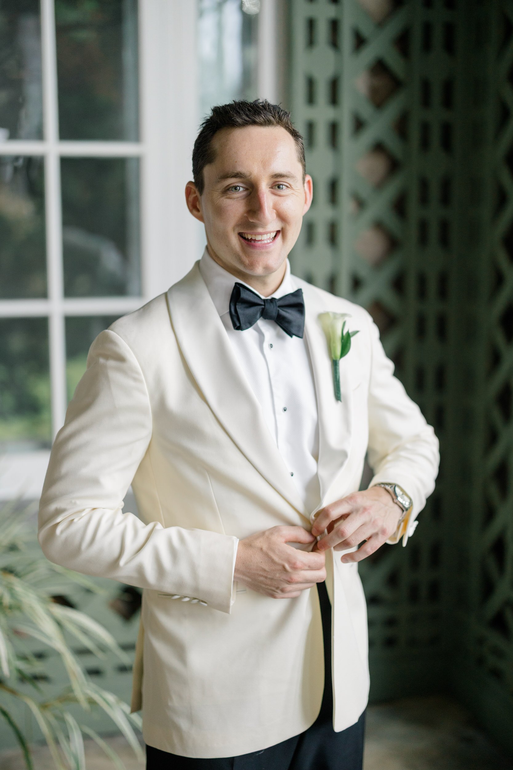 Documentary groom portrait during a Rhode Island garden wedding.
