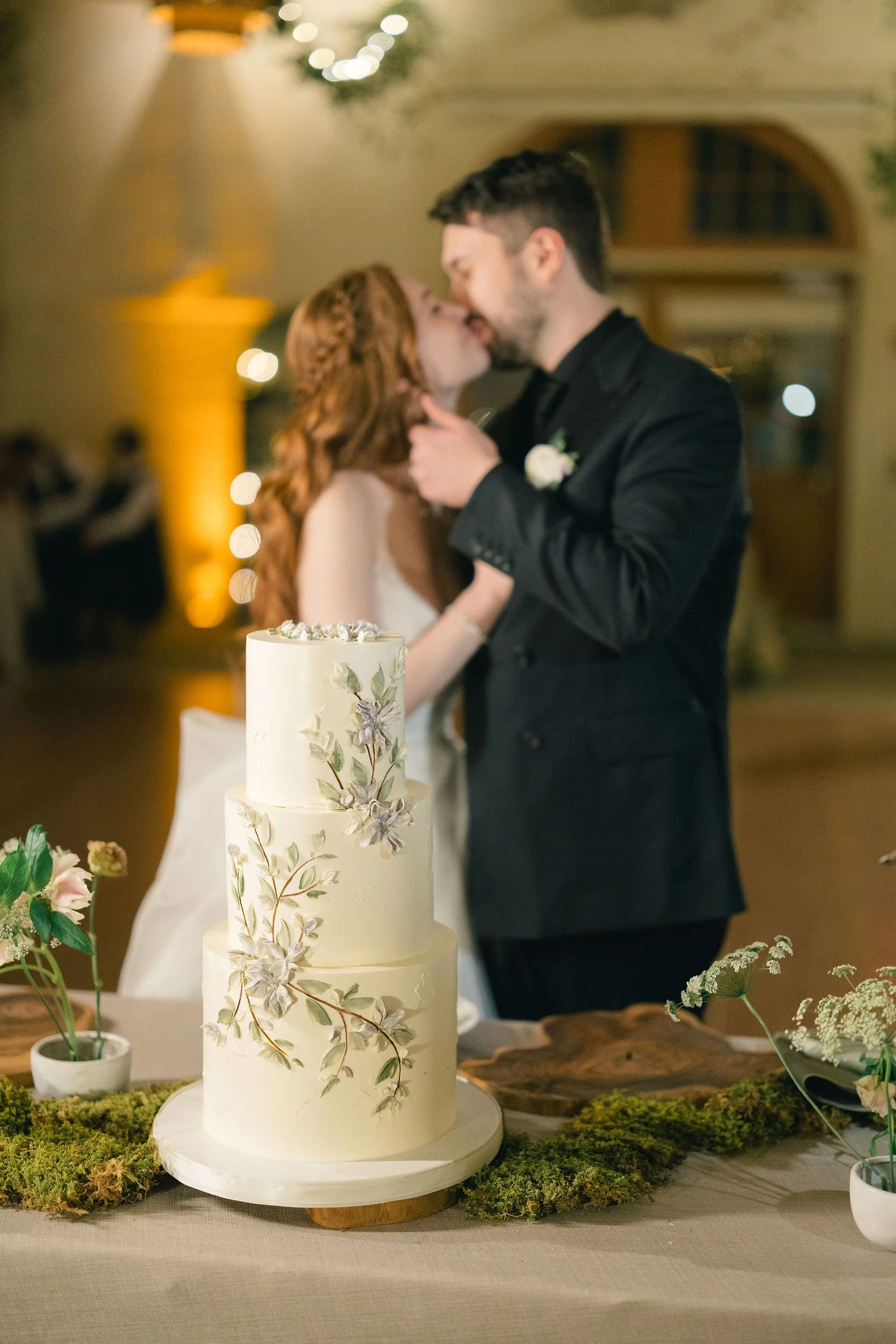 Couple cutting their wedding cake with a sword during a fall wedding celebration.