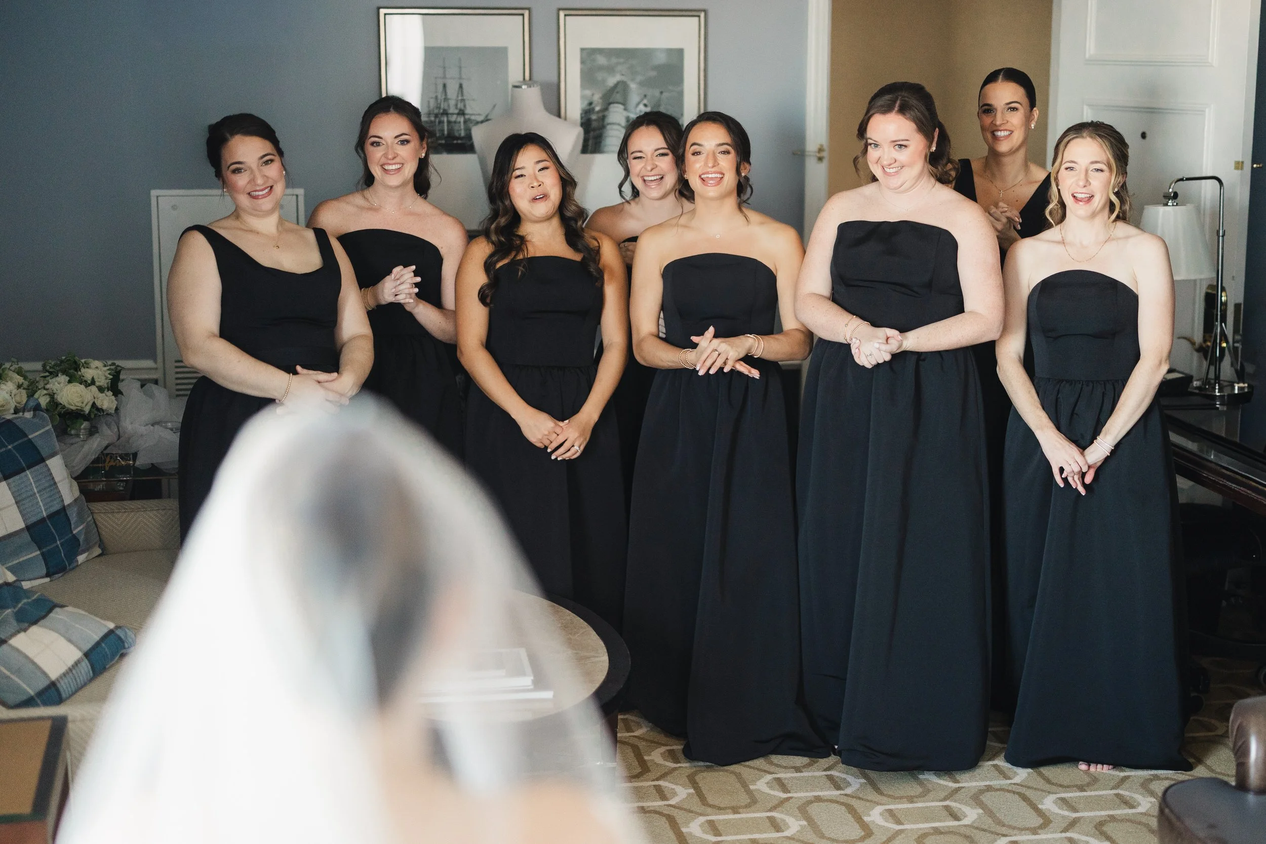 Bride surrounded by bridesmaids while getting ready at the Boston Harbor Hotel
