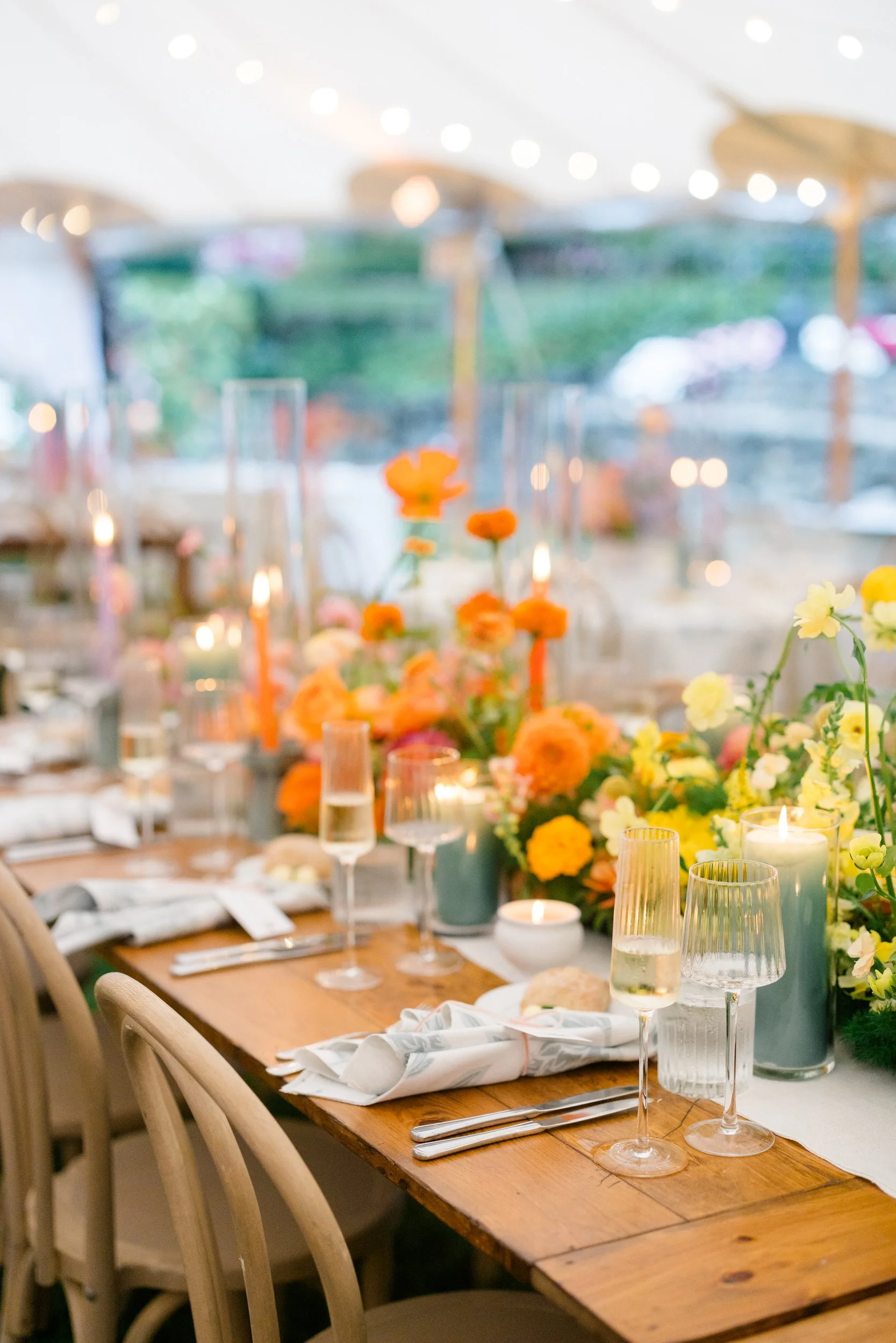 Colorful reception design featuring full-scale trees and abundant seasonal florals.