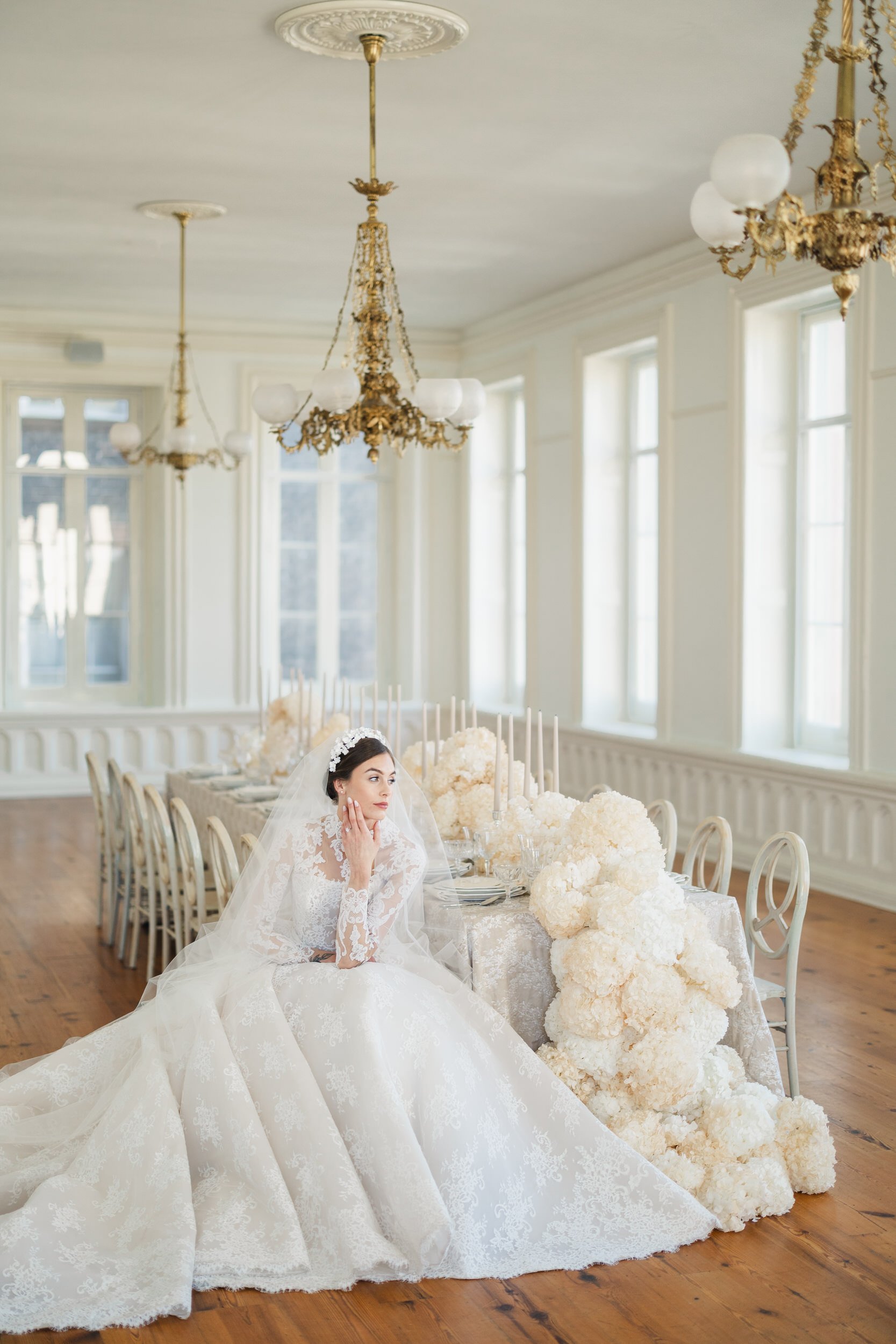 Bride in neutral tones at a candlelit reception table at Brasserie La Banque in Charleston, SC, captured by a Charleston wedding photographer.