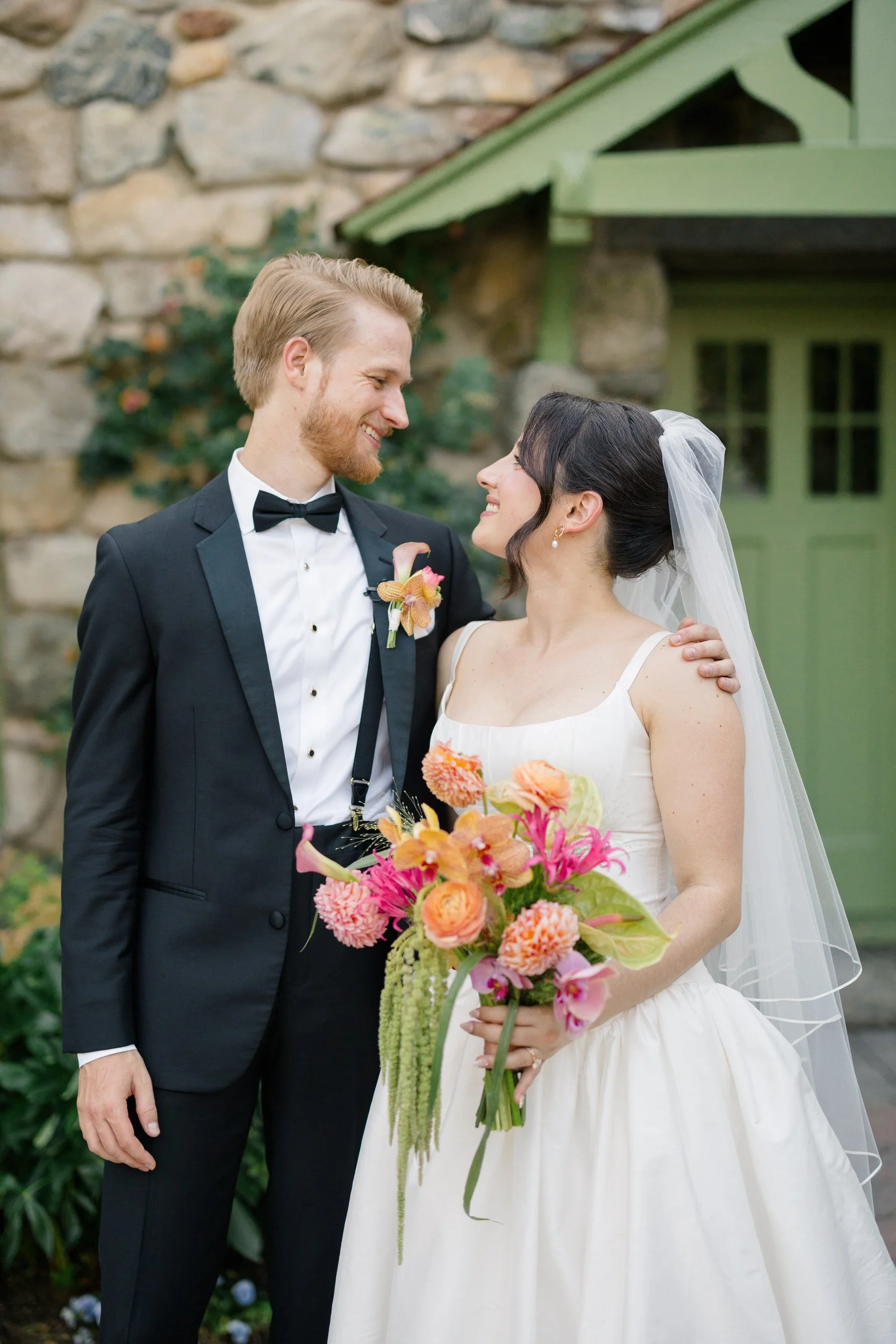 Romantic couple posing in garden setting at Topsfield MA wedding venue with vibrant florals