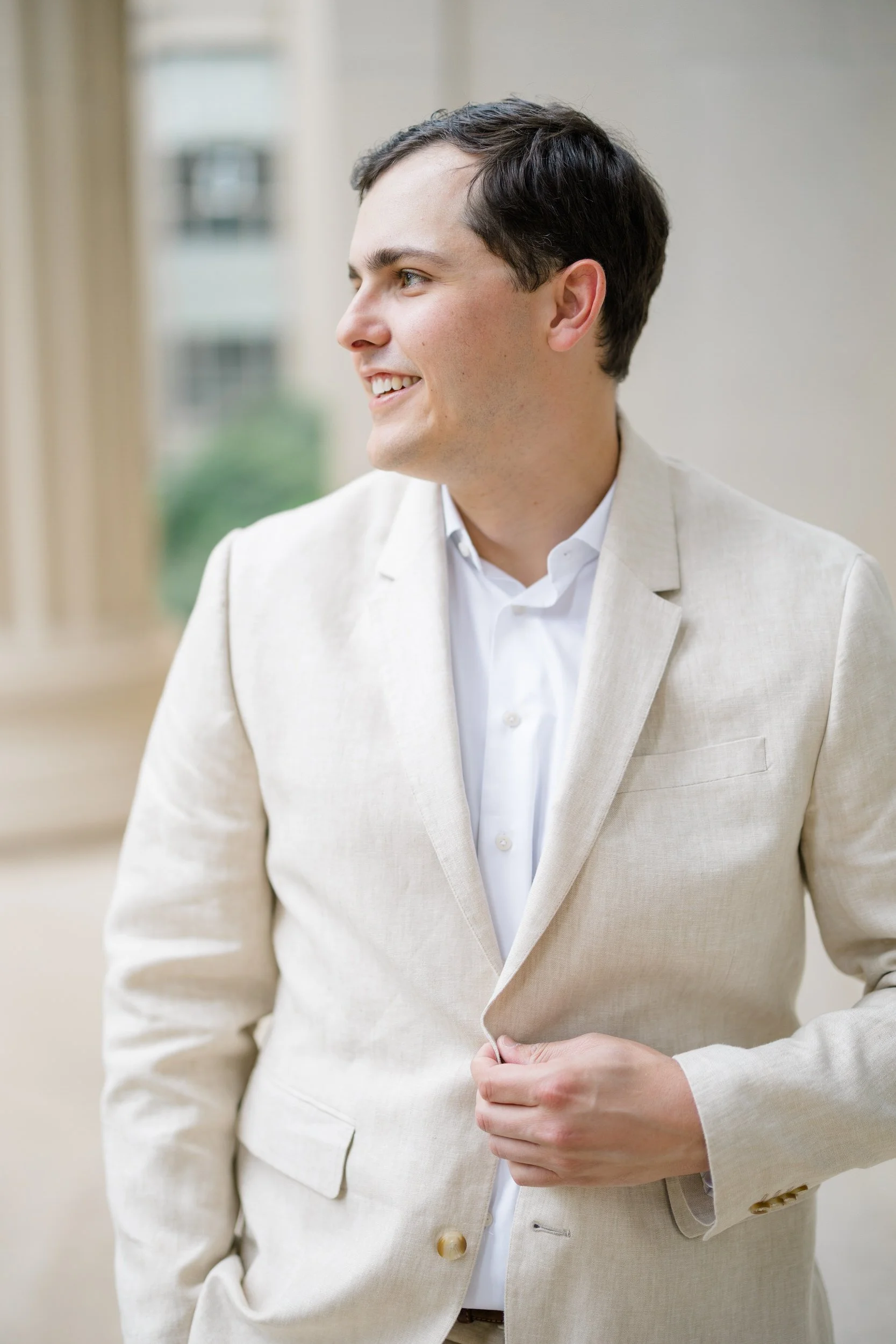 Groom wearing a beige linen suit during a classic Boston engagement session.