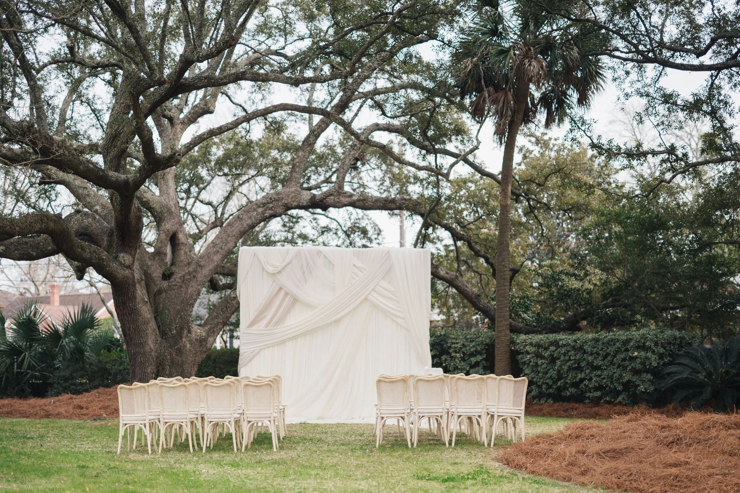 White garden chairs arranged for ceremony at Charleston wedding venue