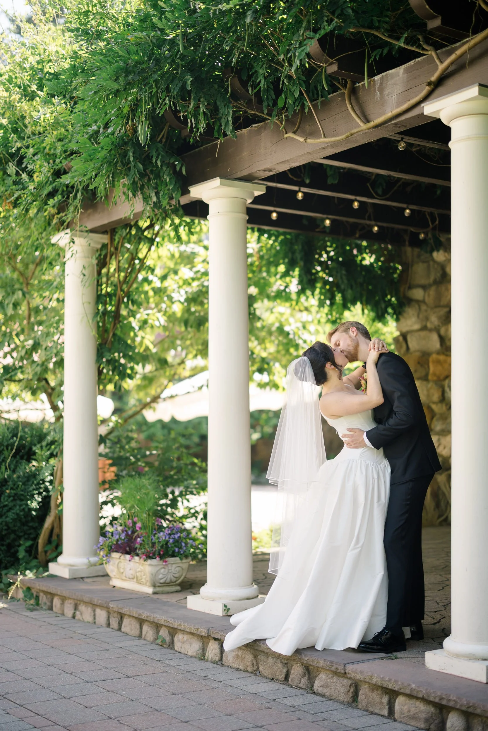 Editorial wedding portraits of bride in basque waist gown and groom in black suit at estate venue