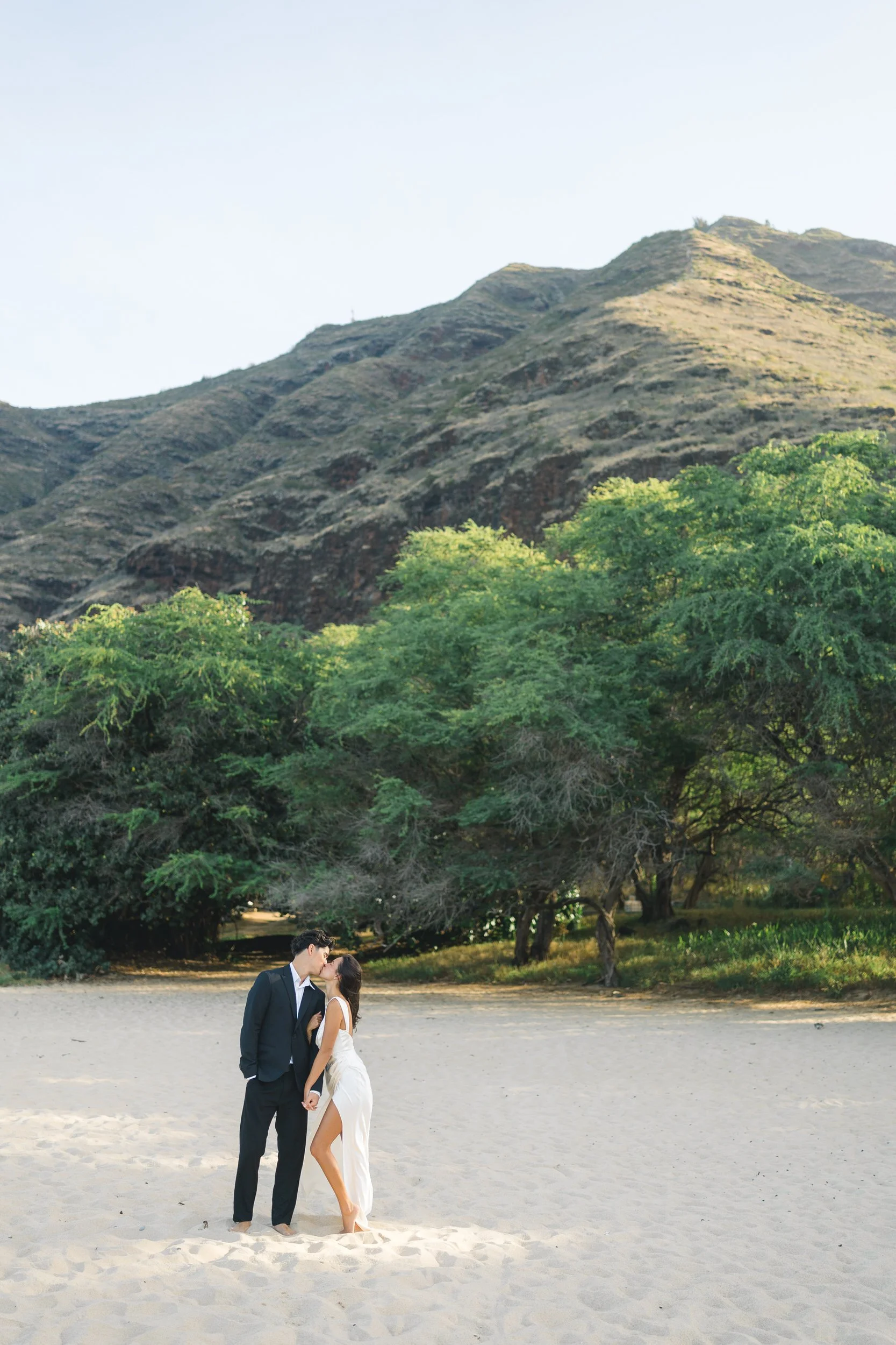 Romantic couple standing on beach during Oahu elopement at sunrise