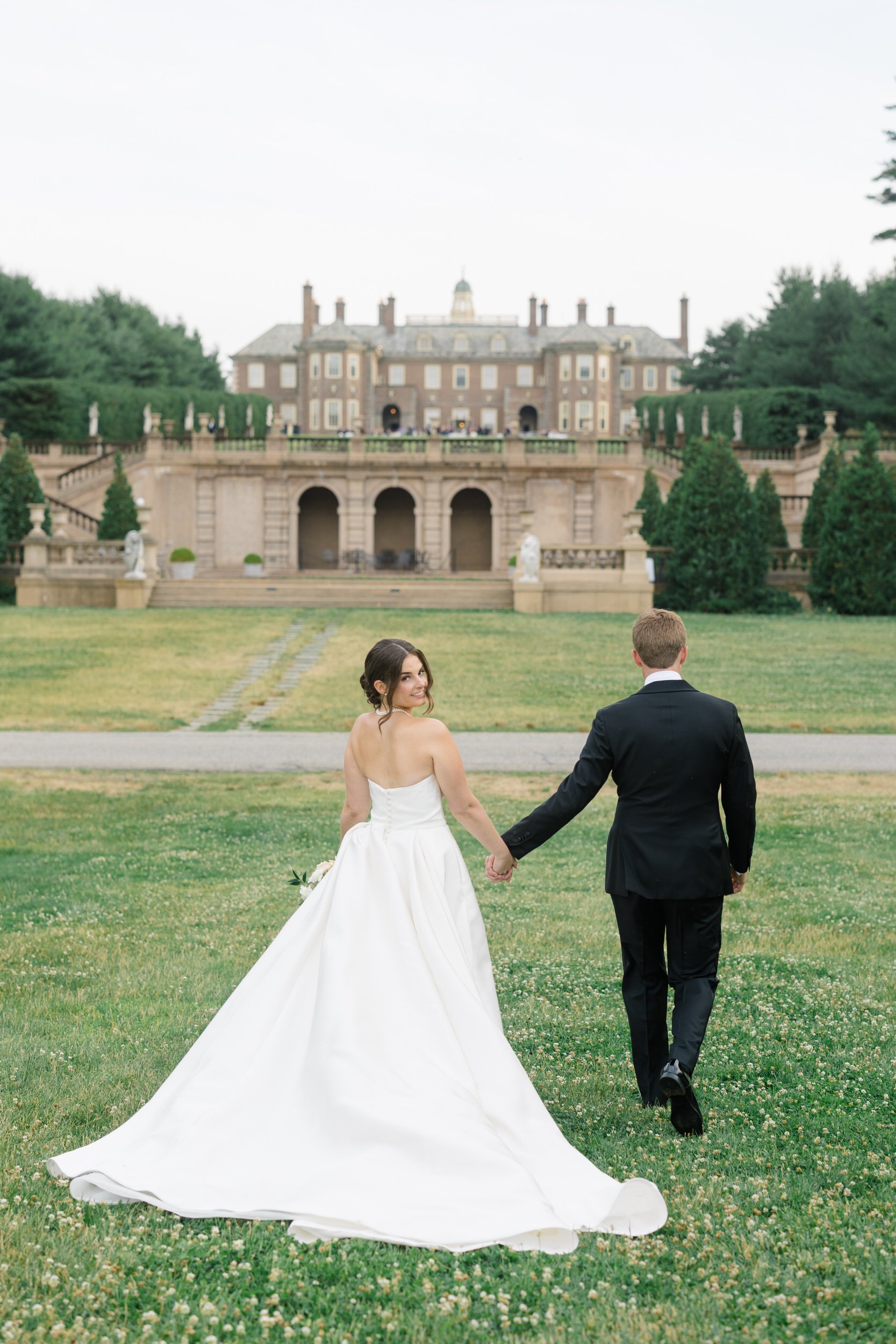 Bride in her Monique Lhuillier gown and groom sharing a quiet moment during sunset at Crane Estate.
