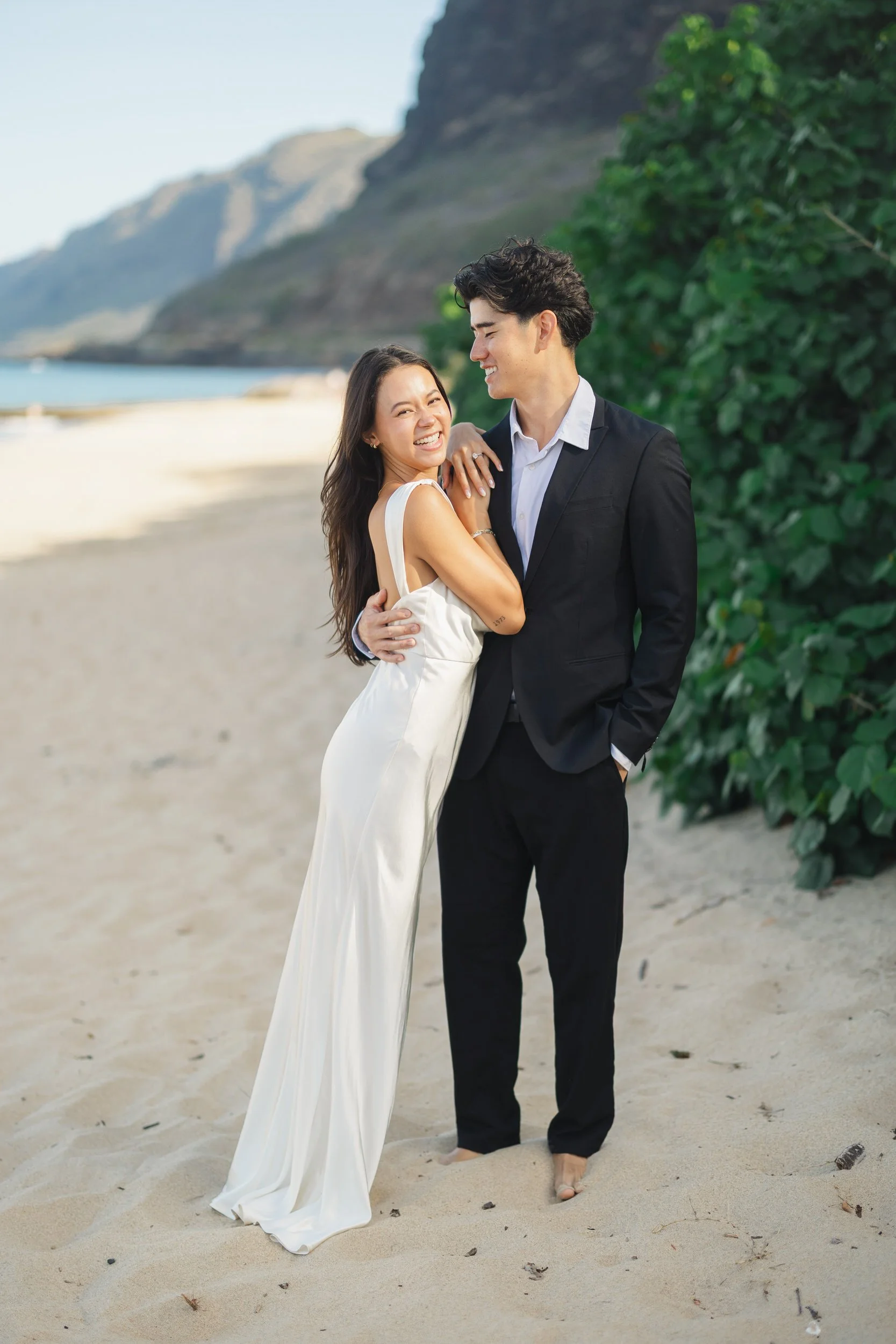 Hawaii elopement couple embracing on Oahu coastline at sunrise