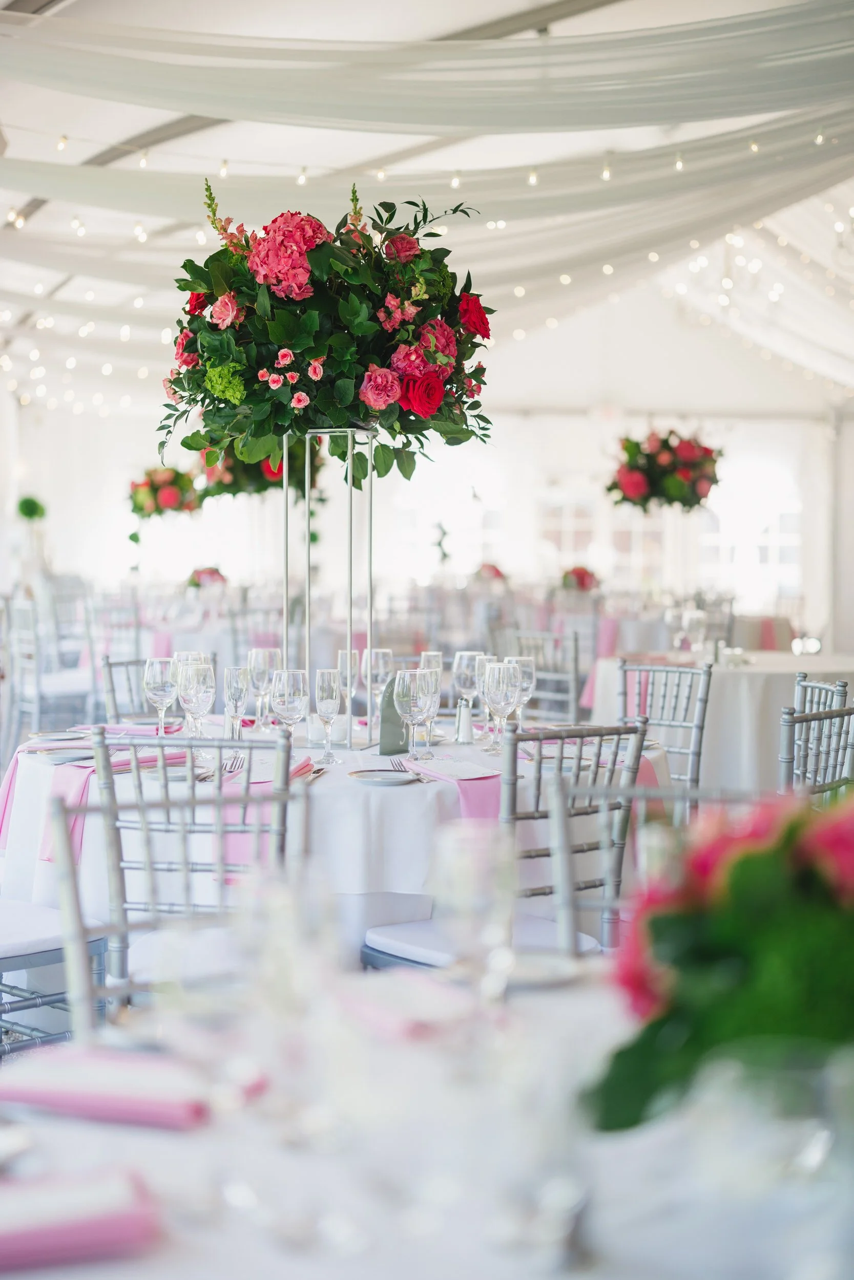 Modern coastal wedding reception with pink, mauve, and green florals