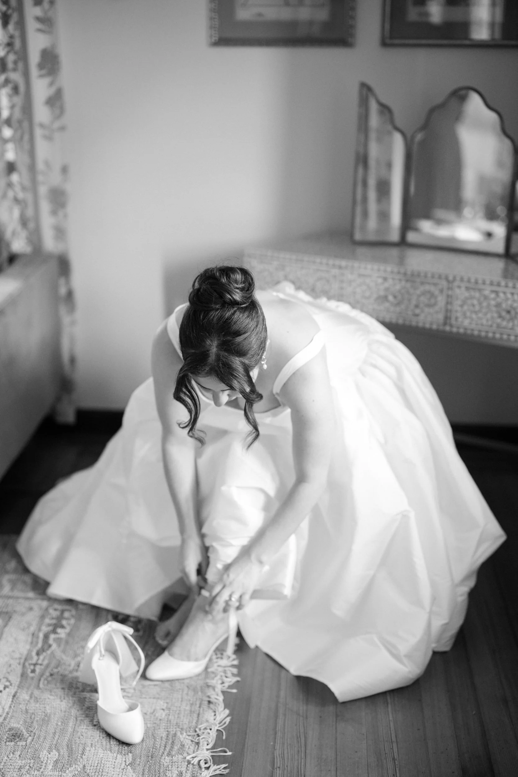 Candid bride getting ready moment in New England estate setting with timeless wedding dress and veil