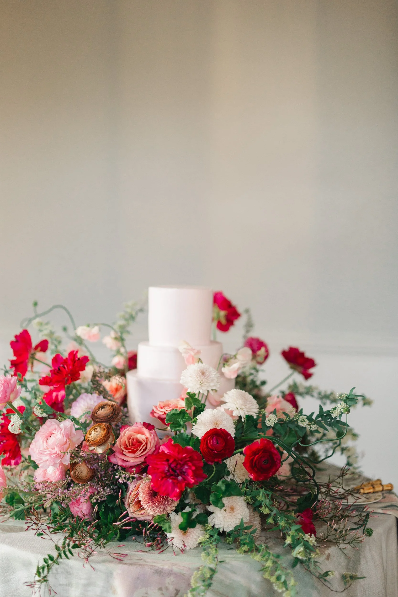Colorful spring wedding cake cutting with guests watching at The Gadsen House.