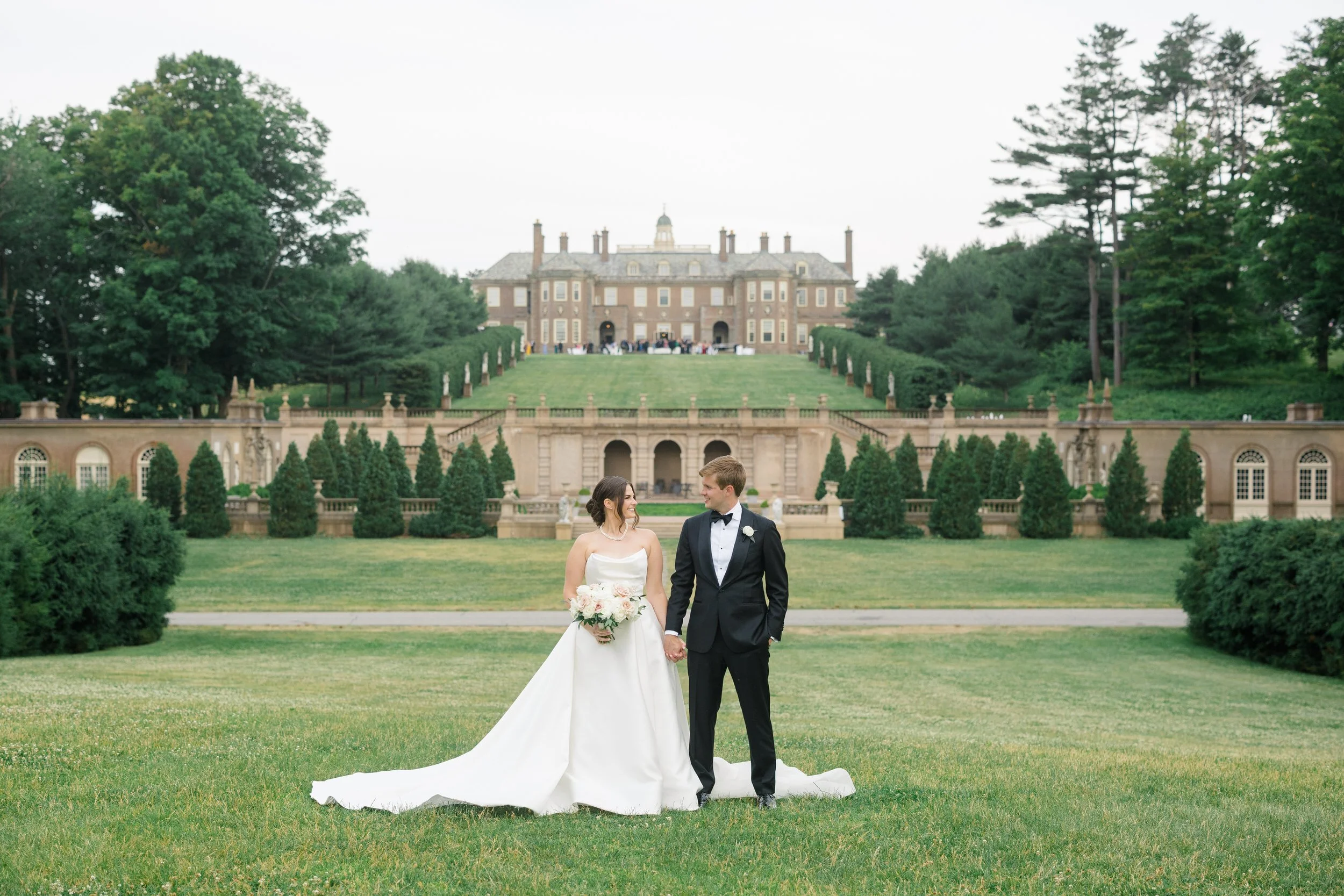 Romantic sunset portraits of the bride and groom with the sweeping grounds of Castle Hill on the Crane Estate in the background.