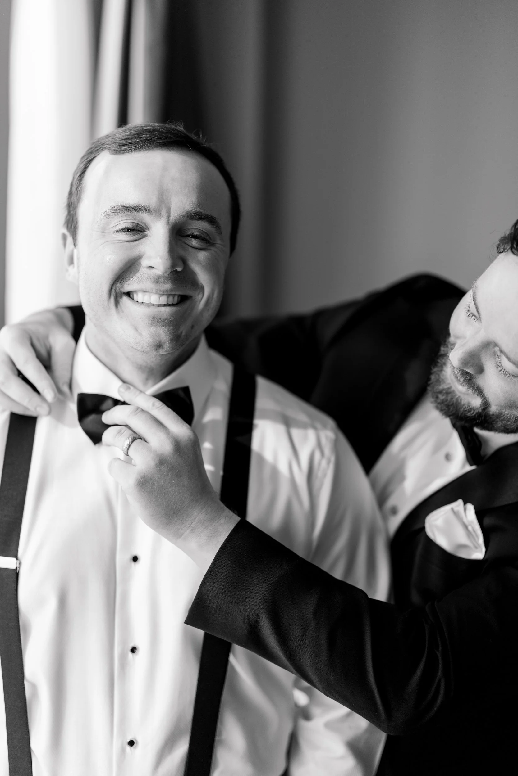 Groom adjusting his tie while preparing at the Boston Harbor Hotel in Boston