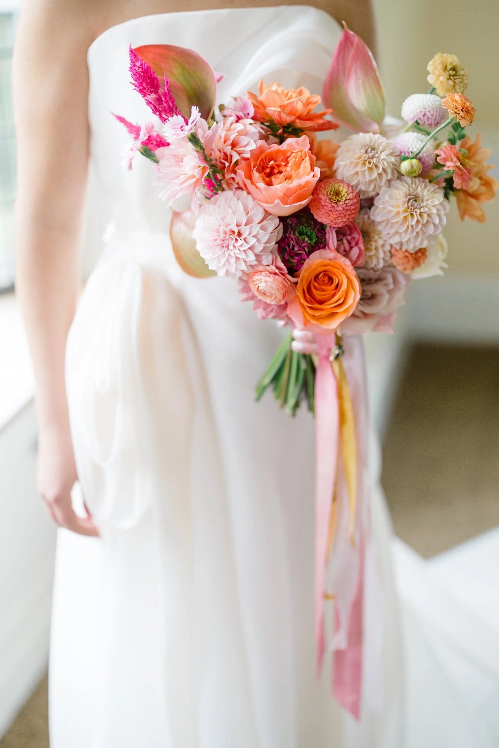 Whimsical bride getting ready surrounded by a vibrant palette of pink, orange, yellow, coral, and red.