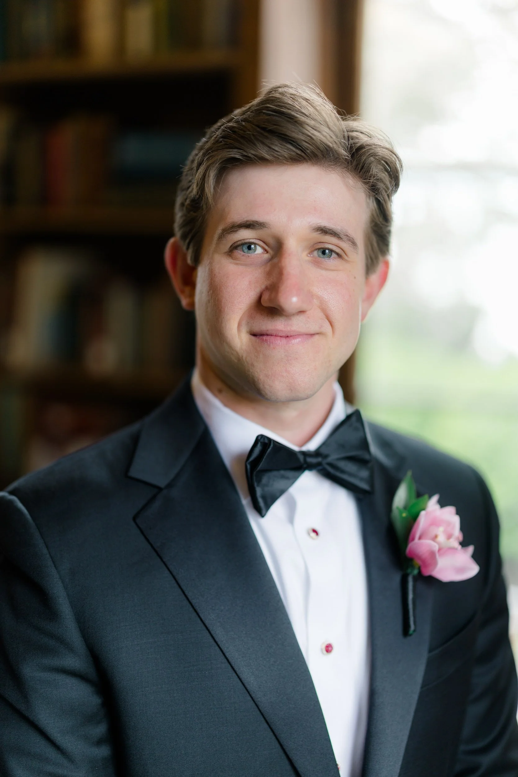 Groom portraits in historic wood-paneled library at coastal Massachusetts wedding