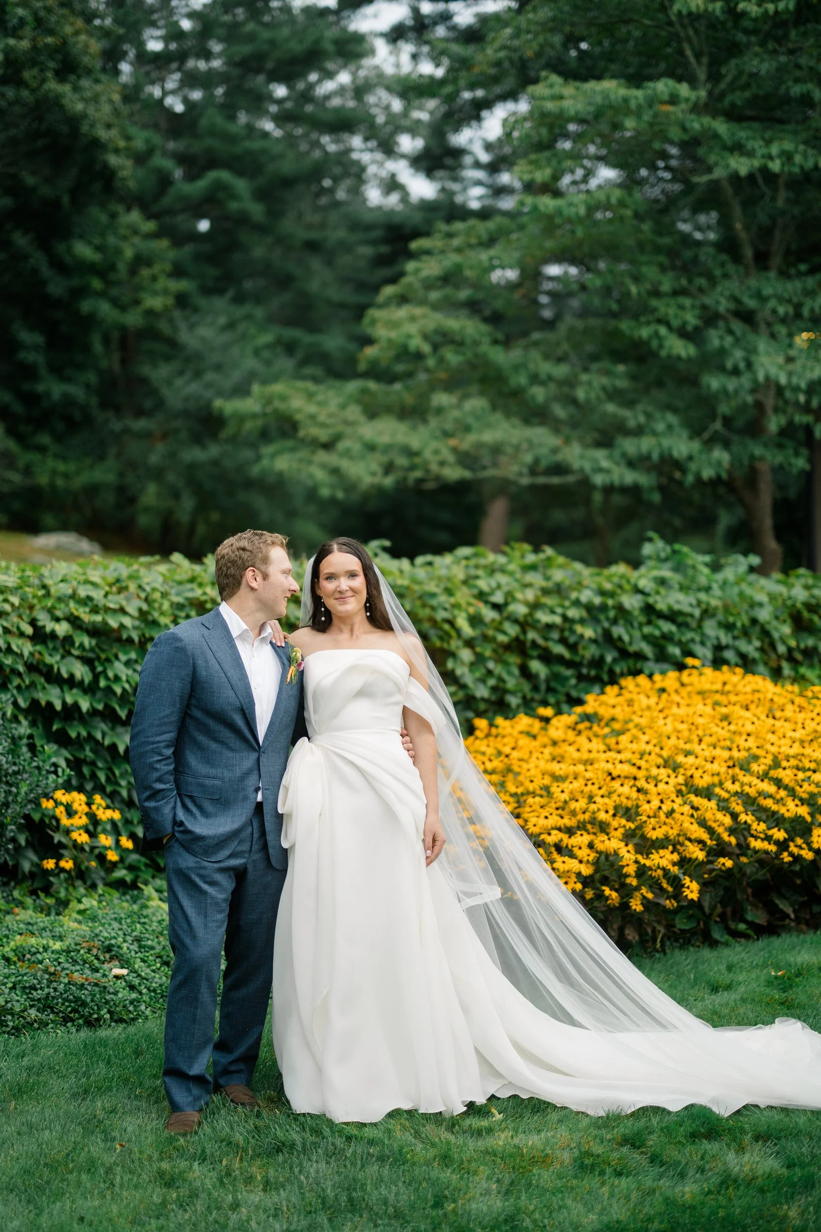 Romantic couple portraits surrounded by bright pink, orange, yellow, and coral flowers.