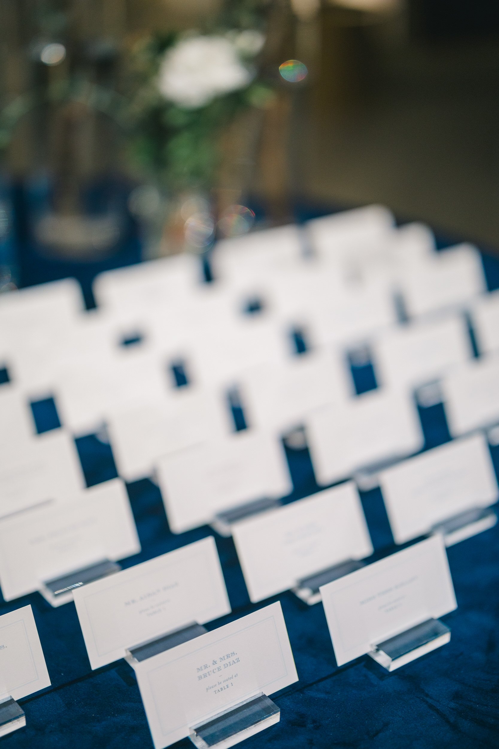 Escort cards displayed for a Boston Athenaeum wedding rehearsal dinner.