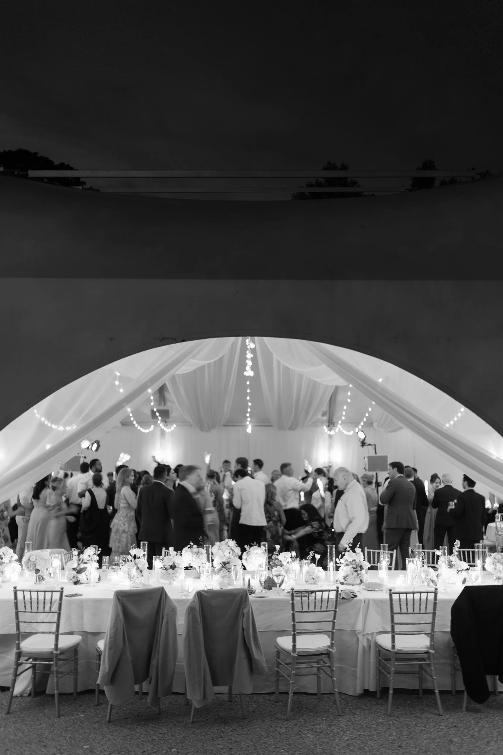 Energetic reception dancing beneath twinkling lights and summer skies.