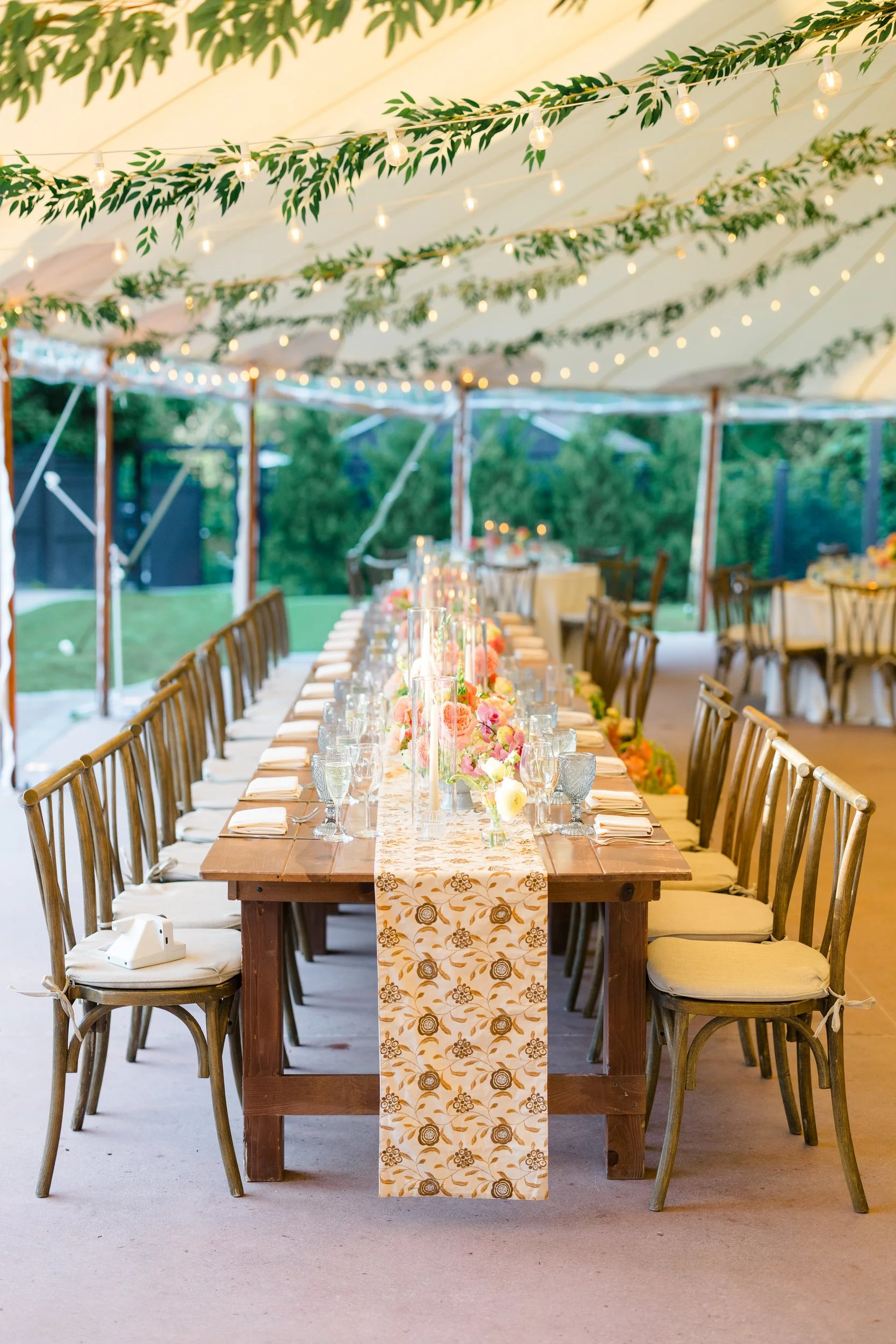 Reception tables styled with colorful floral arrangements featuring orchids dahlias and ranunculus