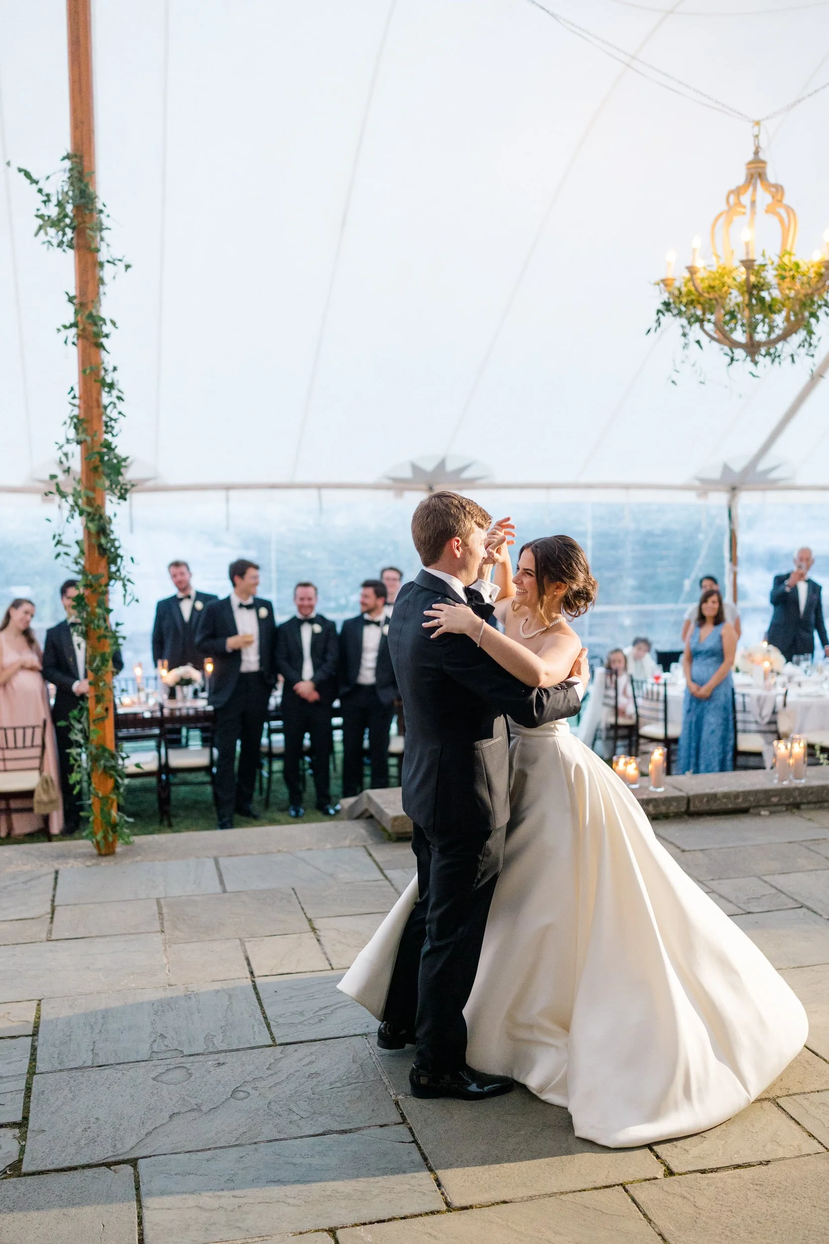 Newlyweds sharing their first dance during an elegant reception inside the sailcloth tent at Castle Hill on the Crane Estate in Ipswich, Massachusetts.