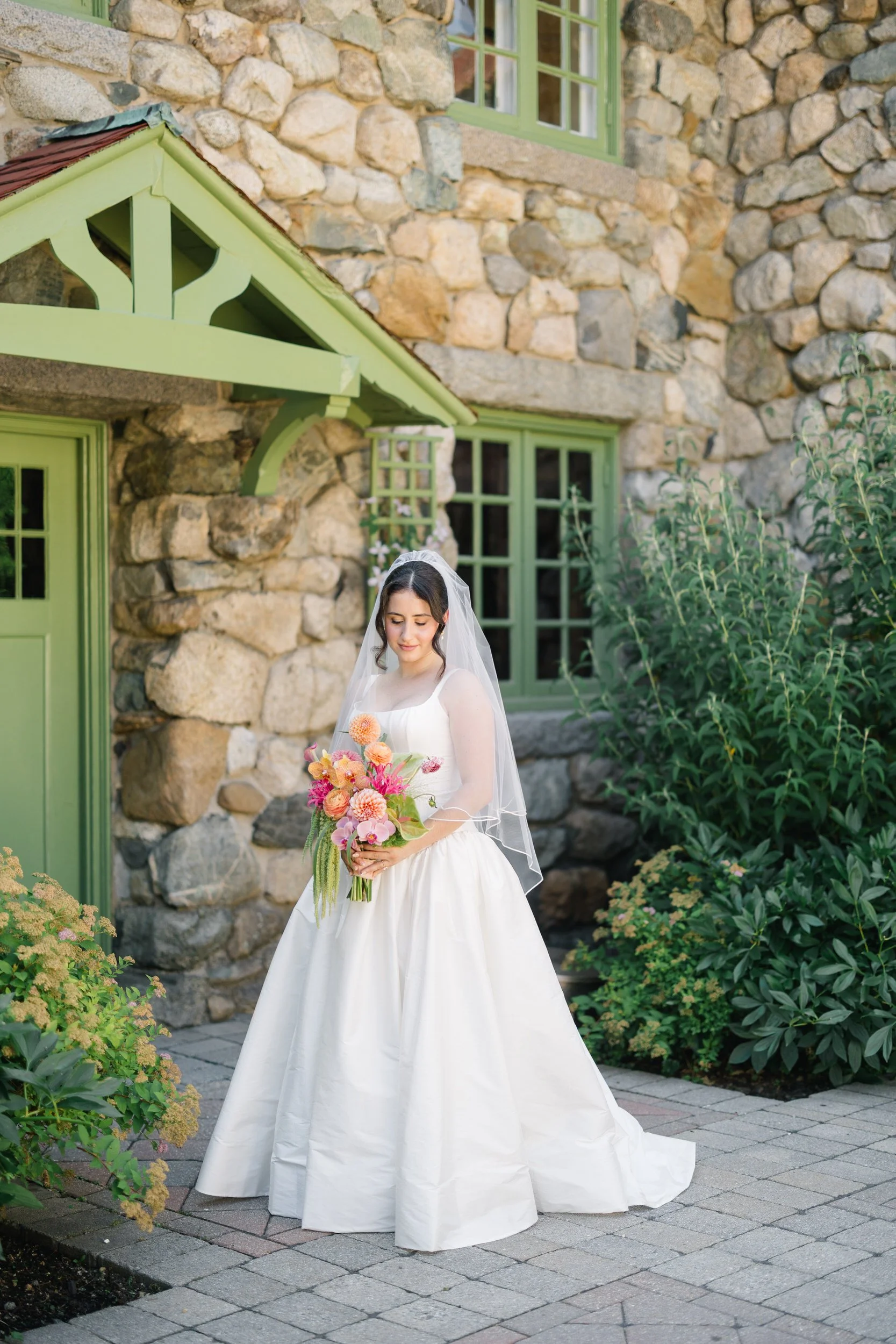 Bride portrait at Willowdale Estate wearing a classic basque waist wedding dress and hip length veil in Topsfield Massachusetts garden setting