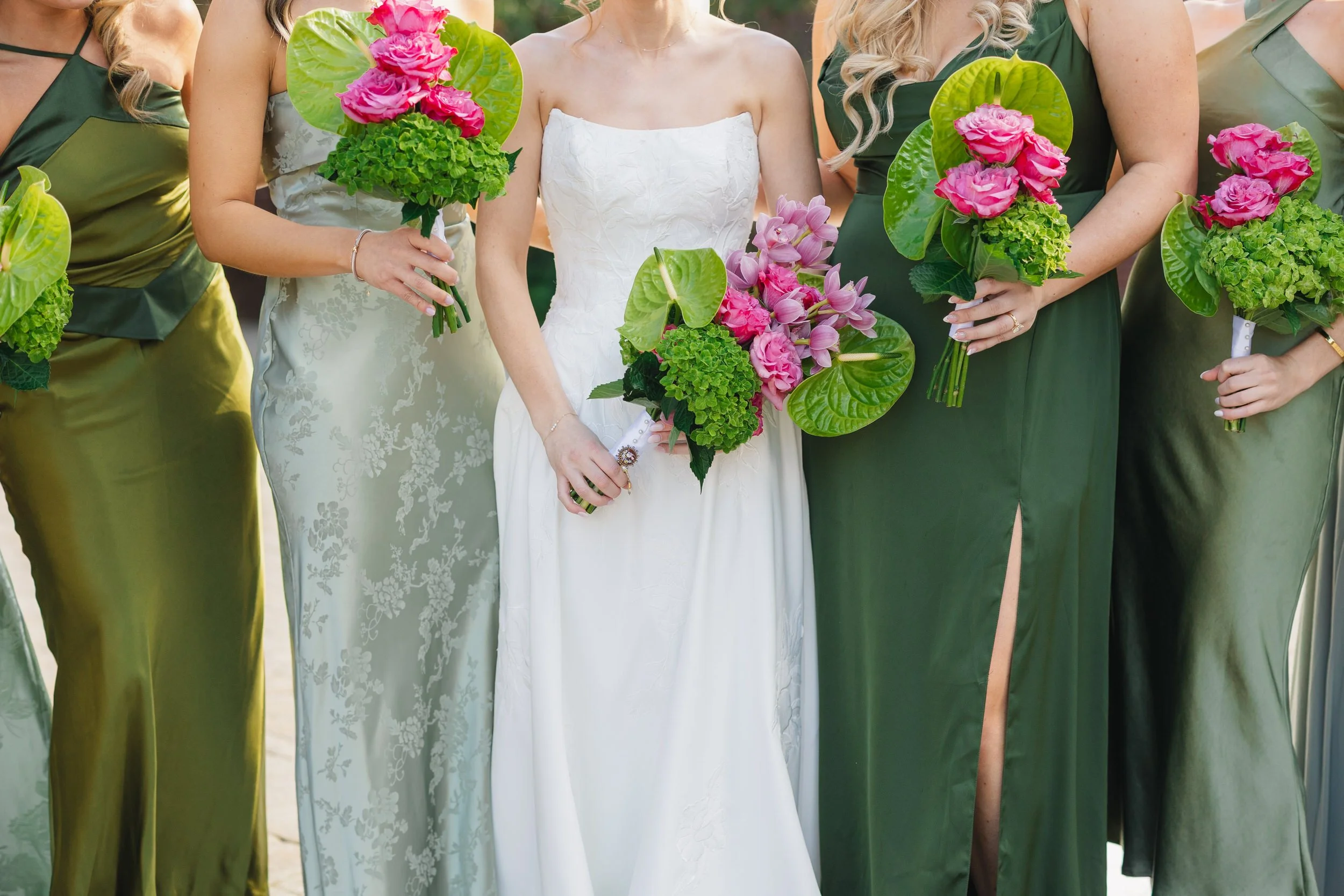 Modern bridesmaids portraits with green, pink, and mauve bouquets