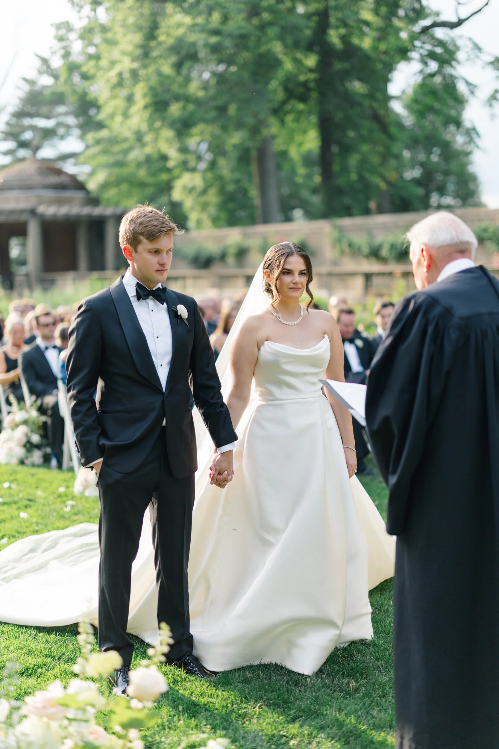 Emotional wedding ceremony in the Italian Garden at Crane Estate surrounded by lush formal gardens.