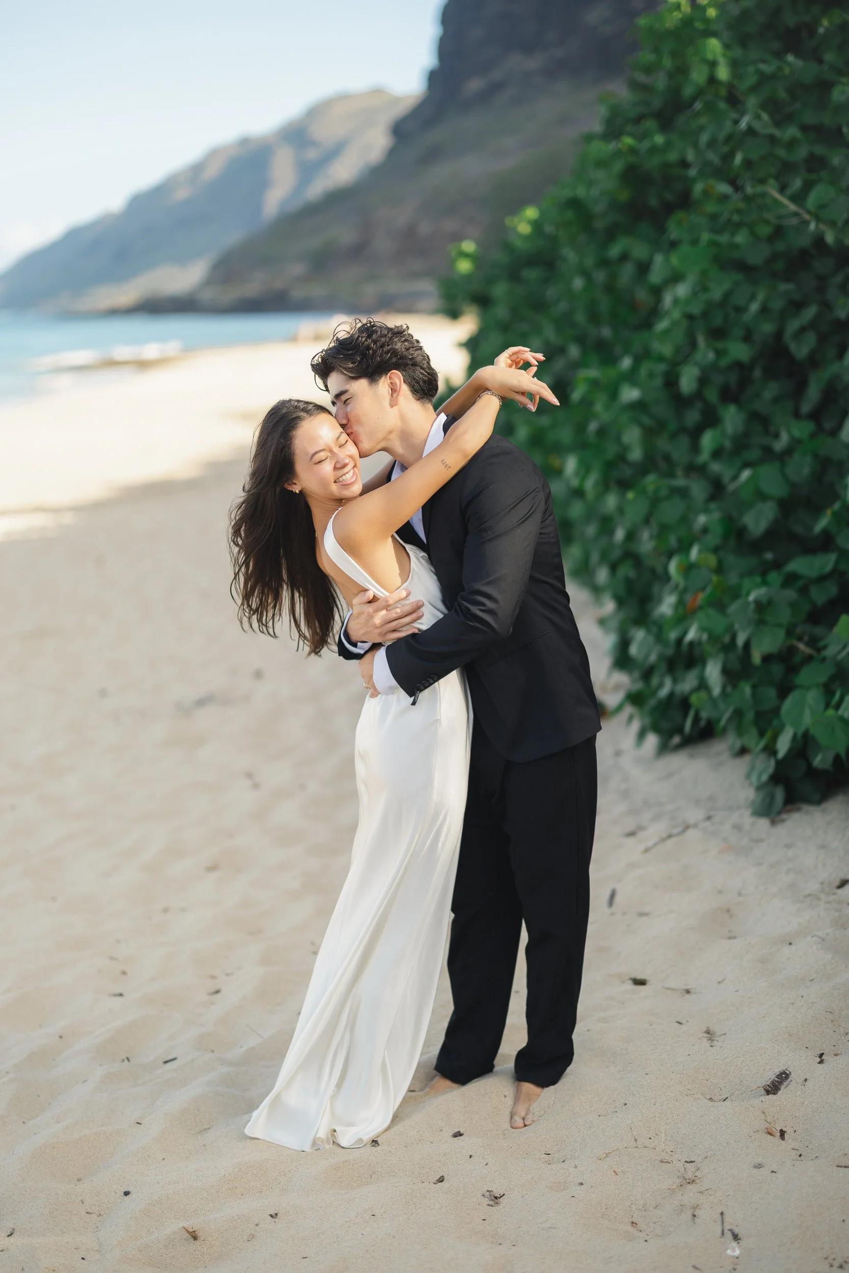 Hawaii elopement couple embracing on Oahu coastline at sunrise