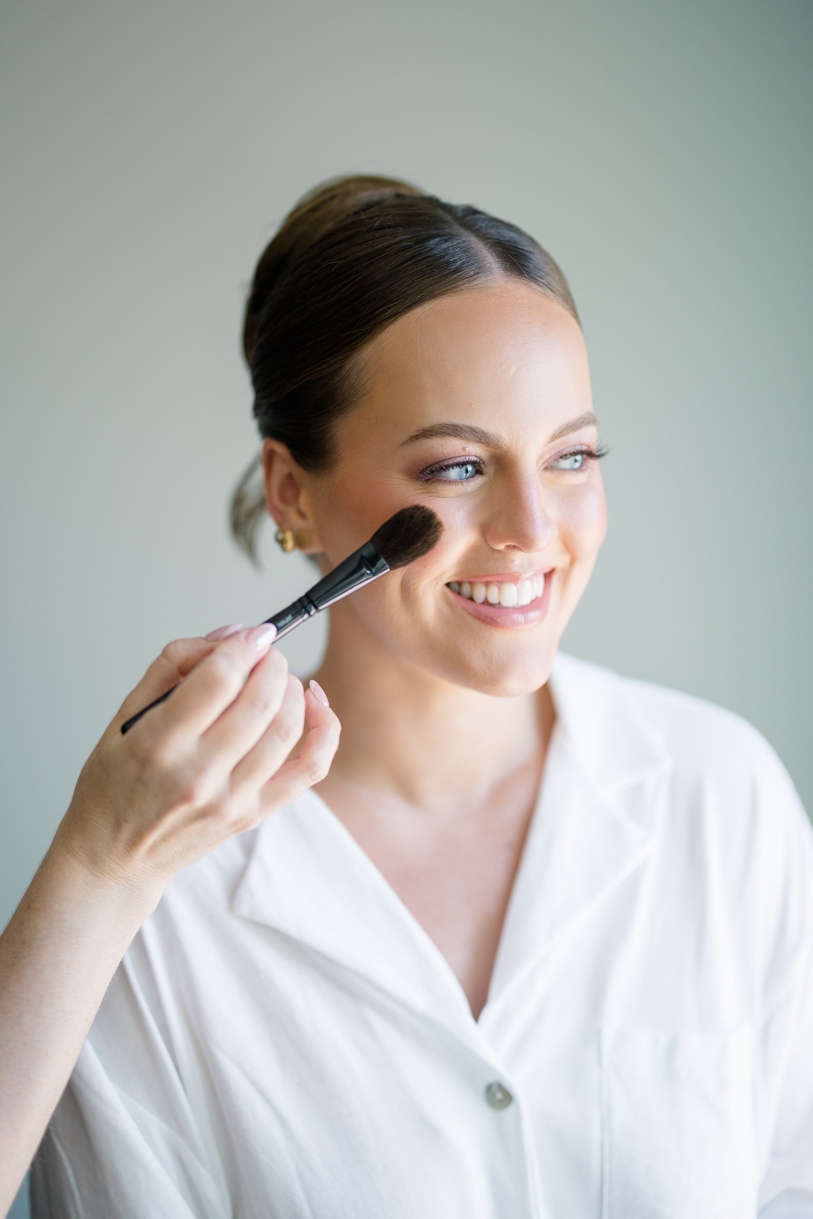 Bride finishing makeup by Jennifer Viros Makeup before her Cape Cod wedding ceremony.