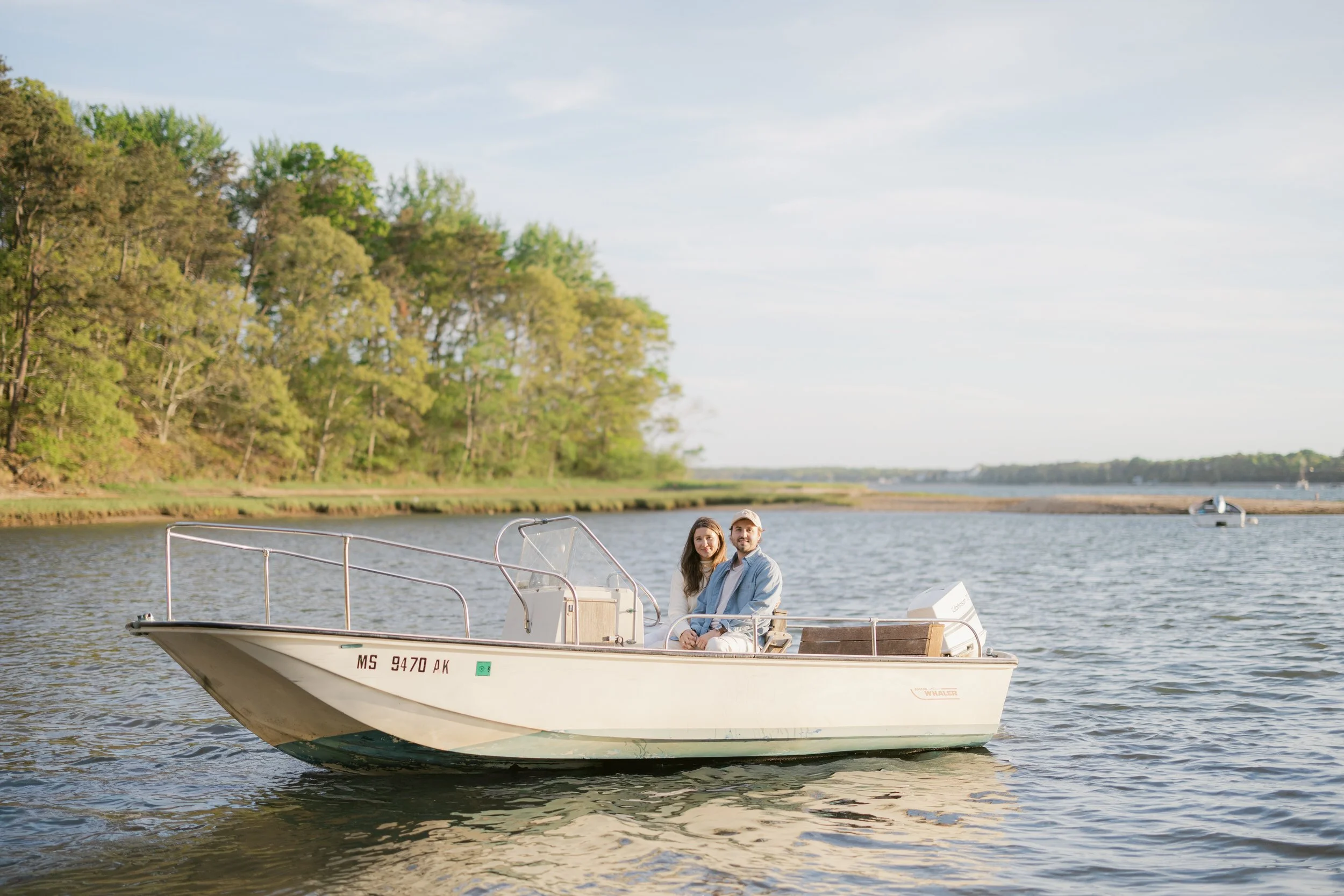 Romantic engagement portraits on a boat during a Chatham Cape Cod engagement session with calm water and golden hour light.
