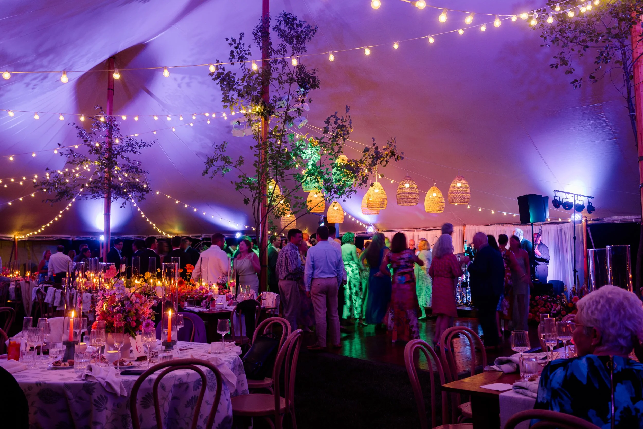 Whimsical colorful wedding reception filled with lush flowers and joyful dancing.