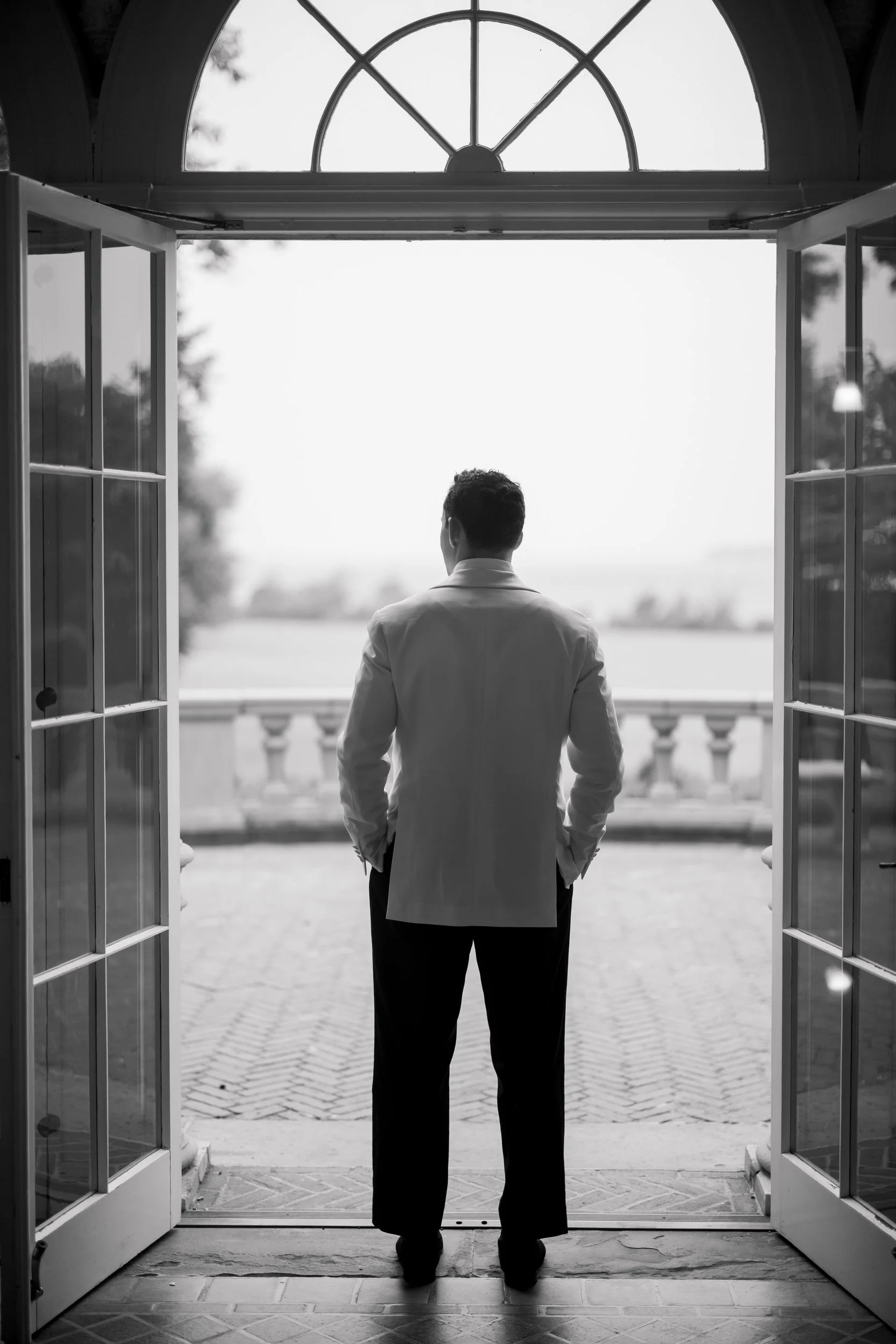 Documentary photograph of the groom preparing for a garden wedding in Rhode Island.