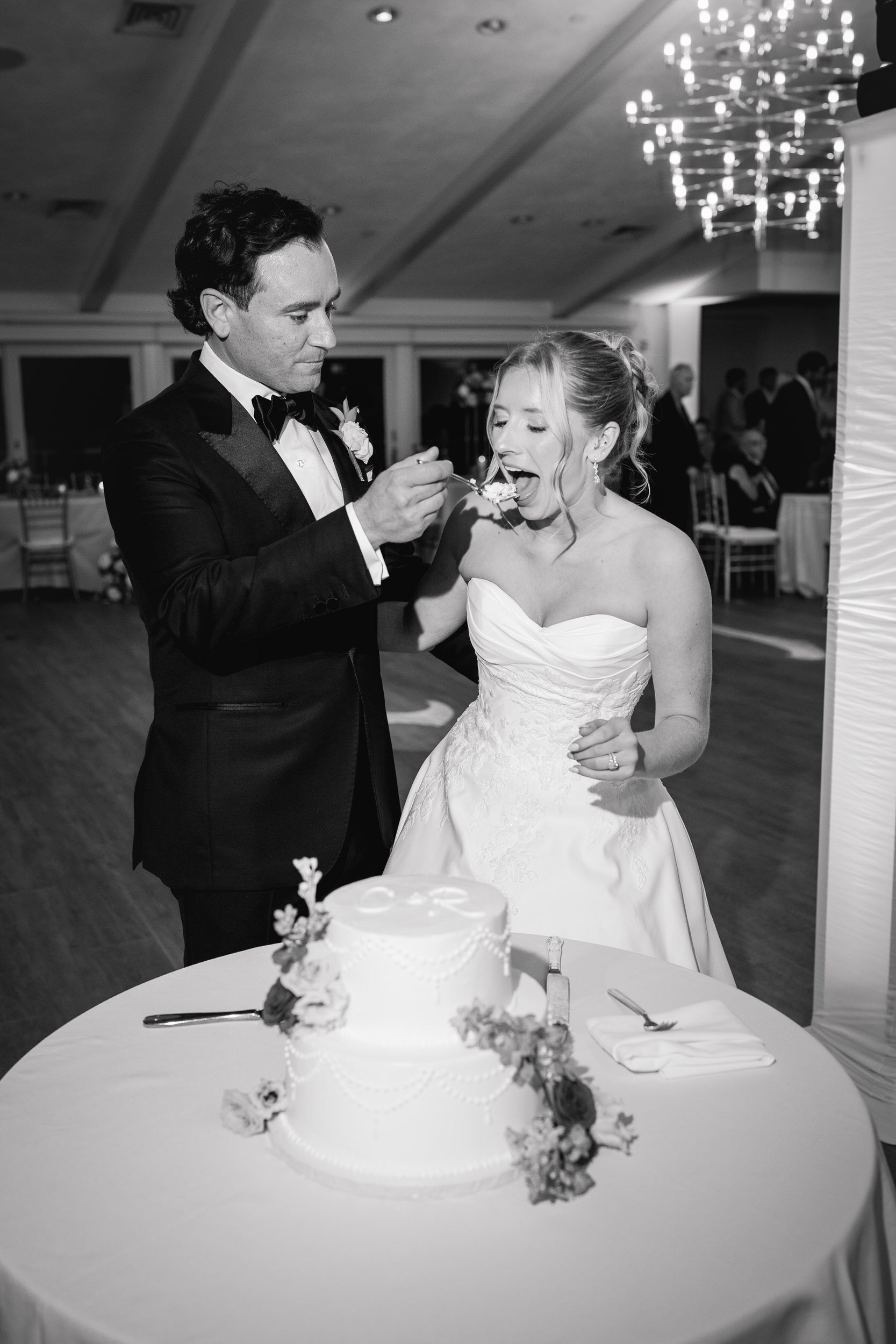 Couple cutting their wedding cake during their Wychmere Beach Club Ocean Room reception.
