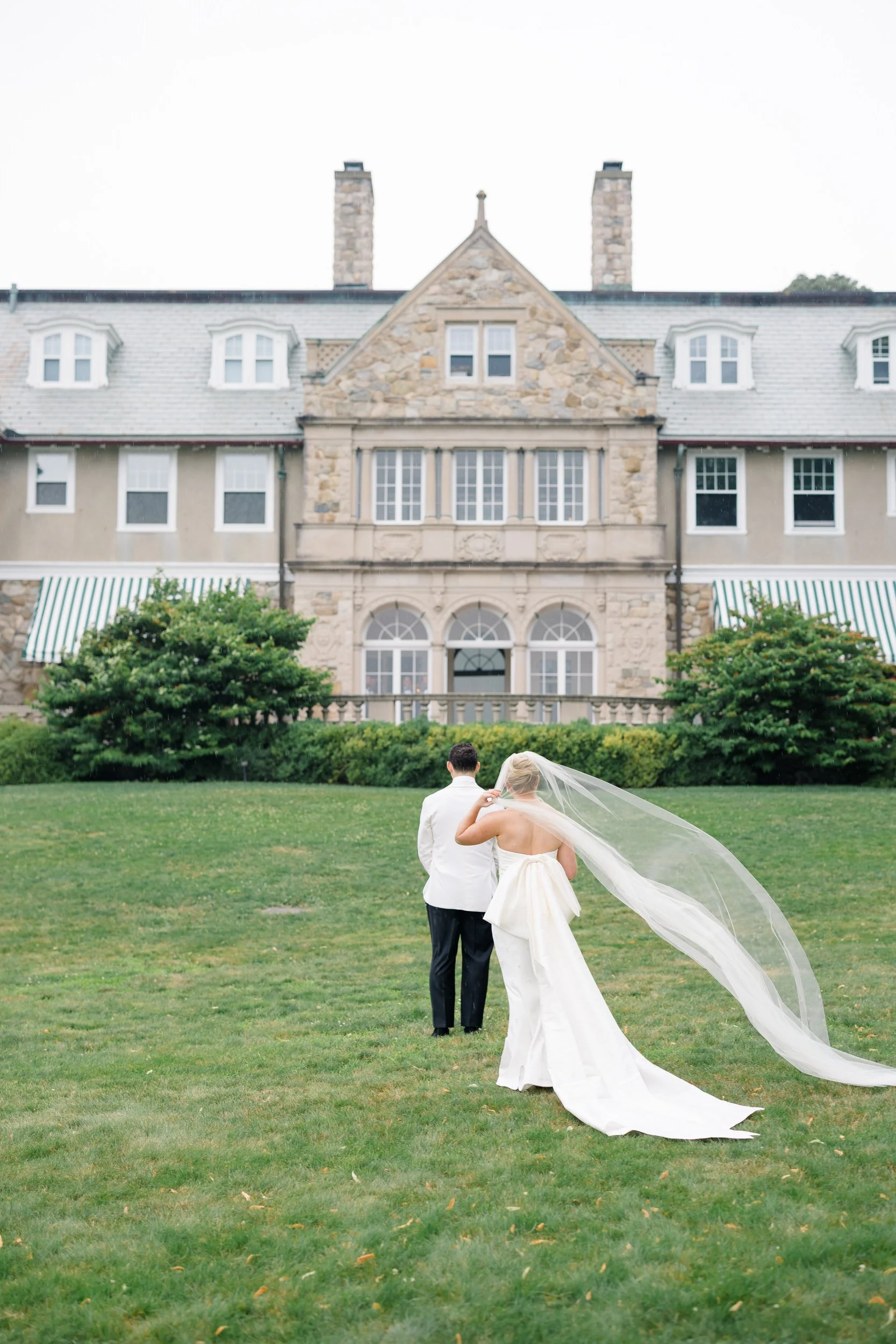 Bride wearing a cathedral veil during her first look at Blithewold Mansion.