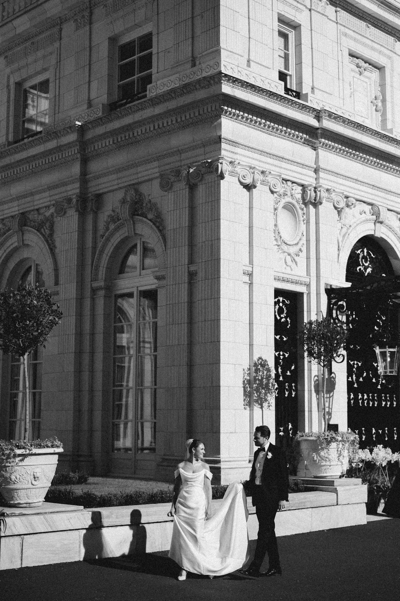 Couple walking the grounds of Rosecliff Mansion during wedding portraits