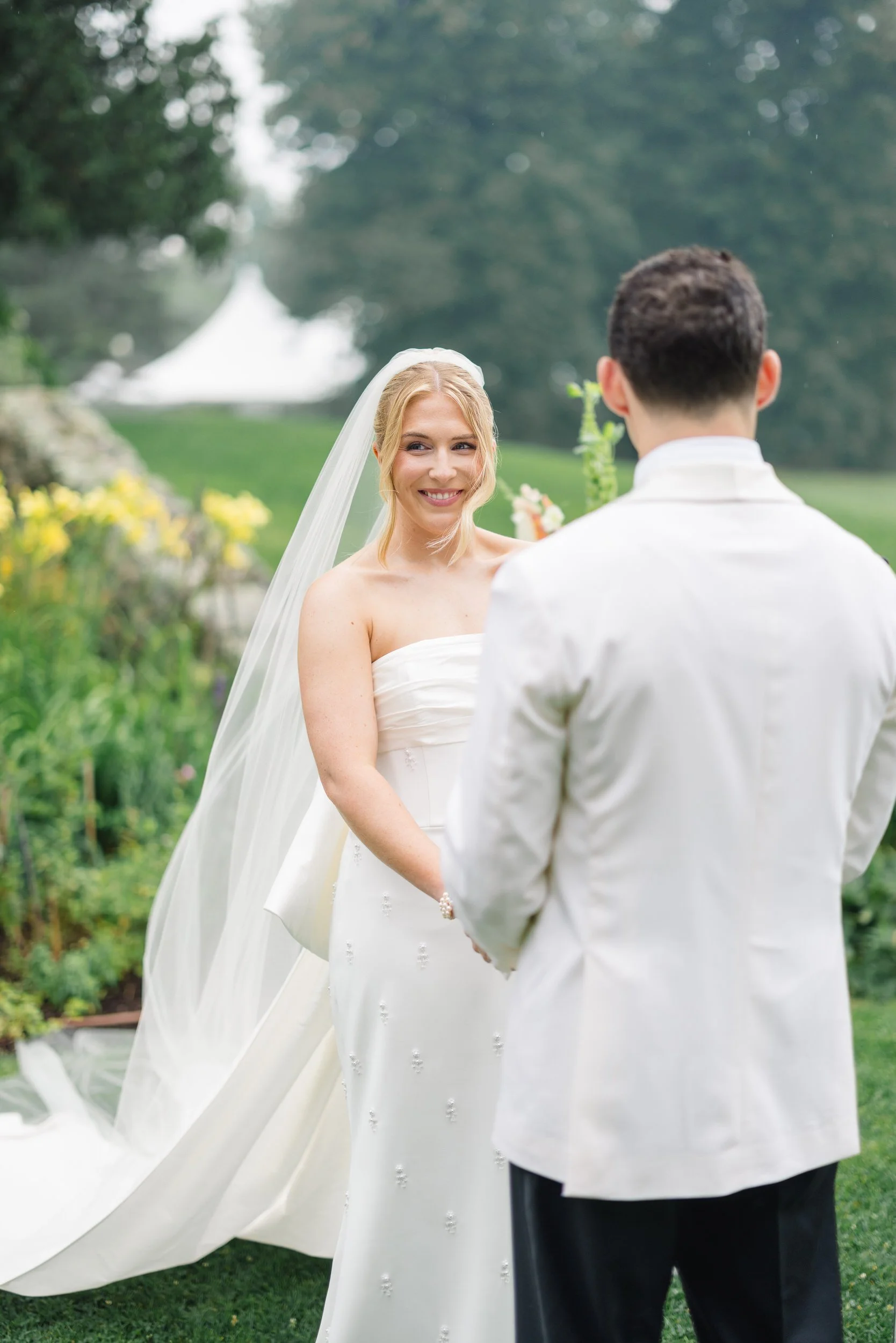 Rainy Blithewold Wedding ceremony surrounded by colorful wildflower-inspired florals.