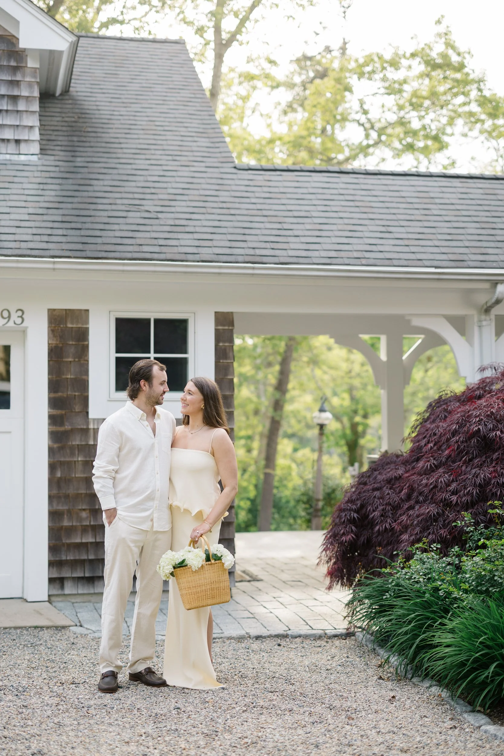 Couple at a Cape Cod cottage during a Chatham Cape Cod engagement session, styled with coastal chic details and soft natural light.
