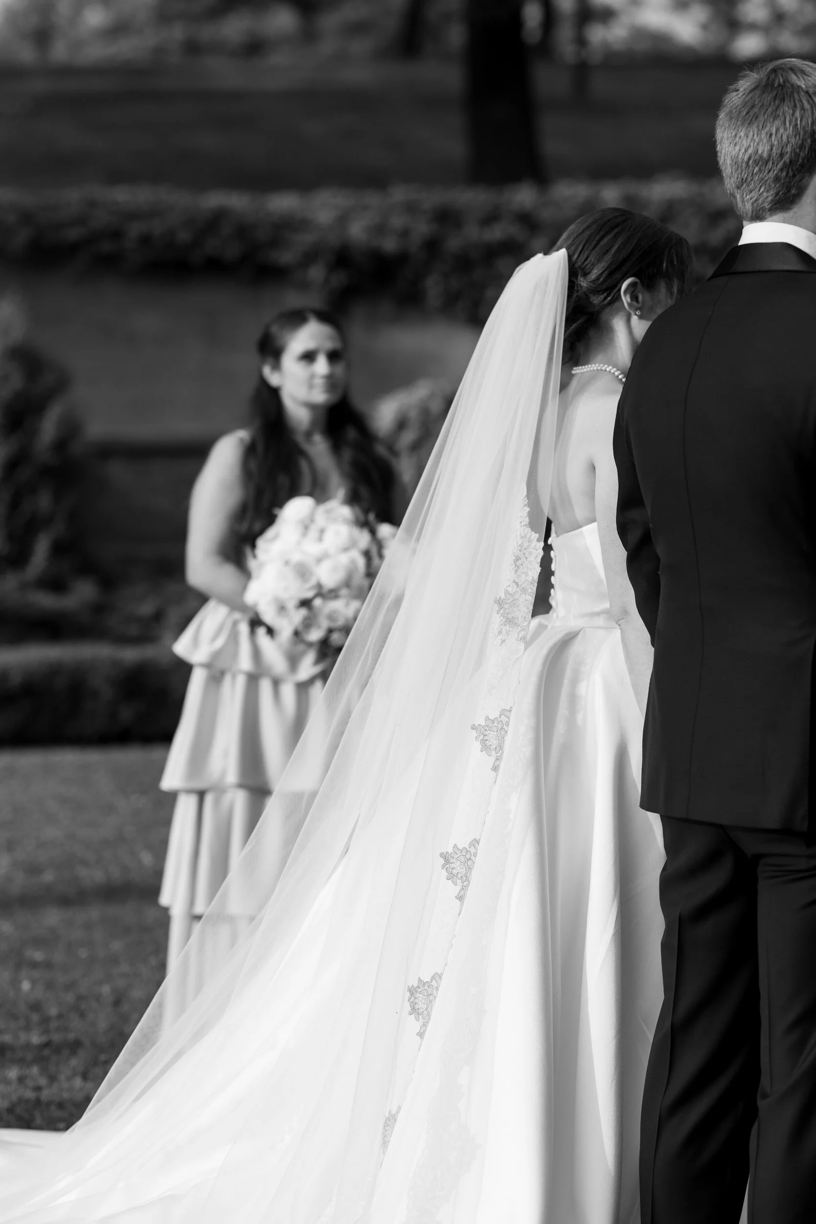 Outdoor summer wedding ceremony in the Italian Garden at Castle Hill veil detail surrounded by estate gardens.