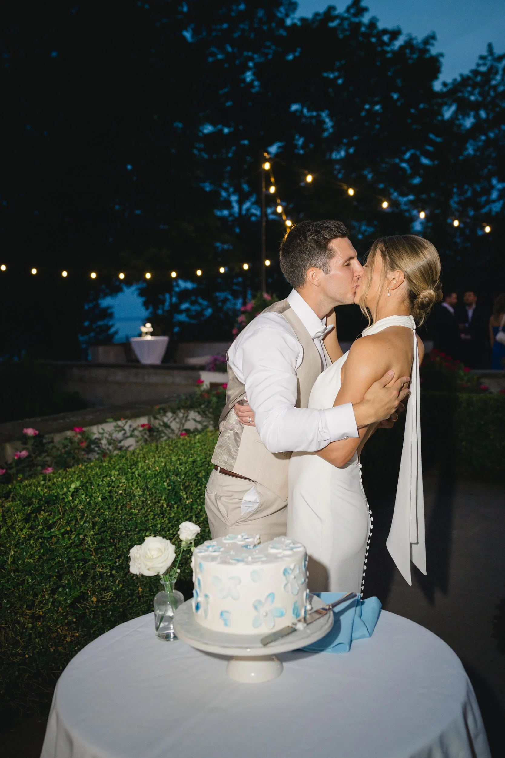 Newlyweds sharing cake during their summer wedding celebration.