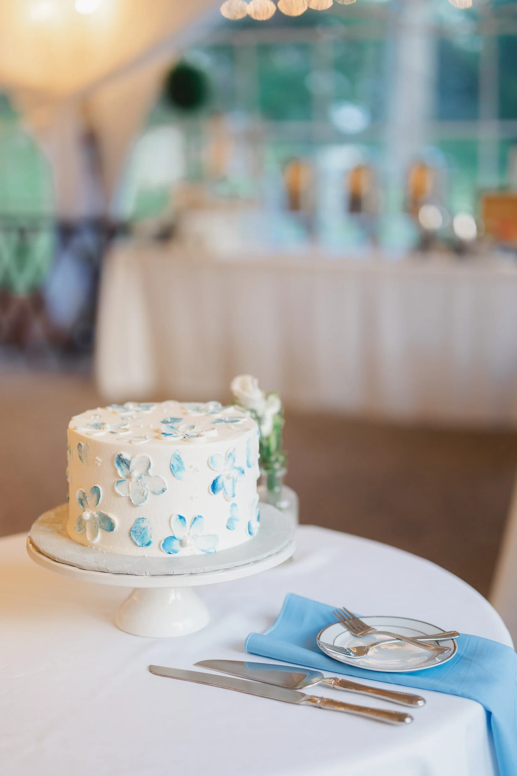 Elegant wedding cake display with white and pastel blue floral accents.