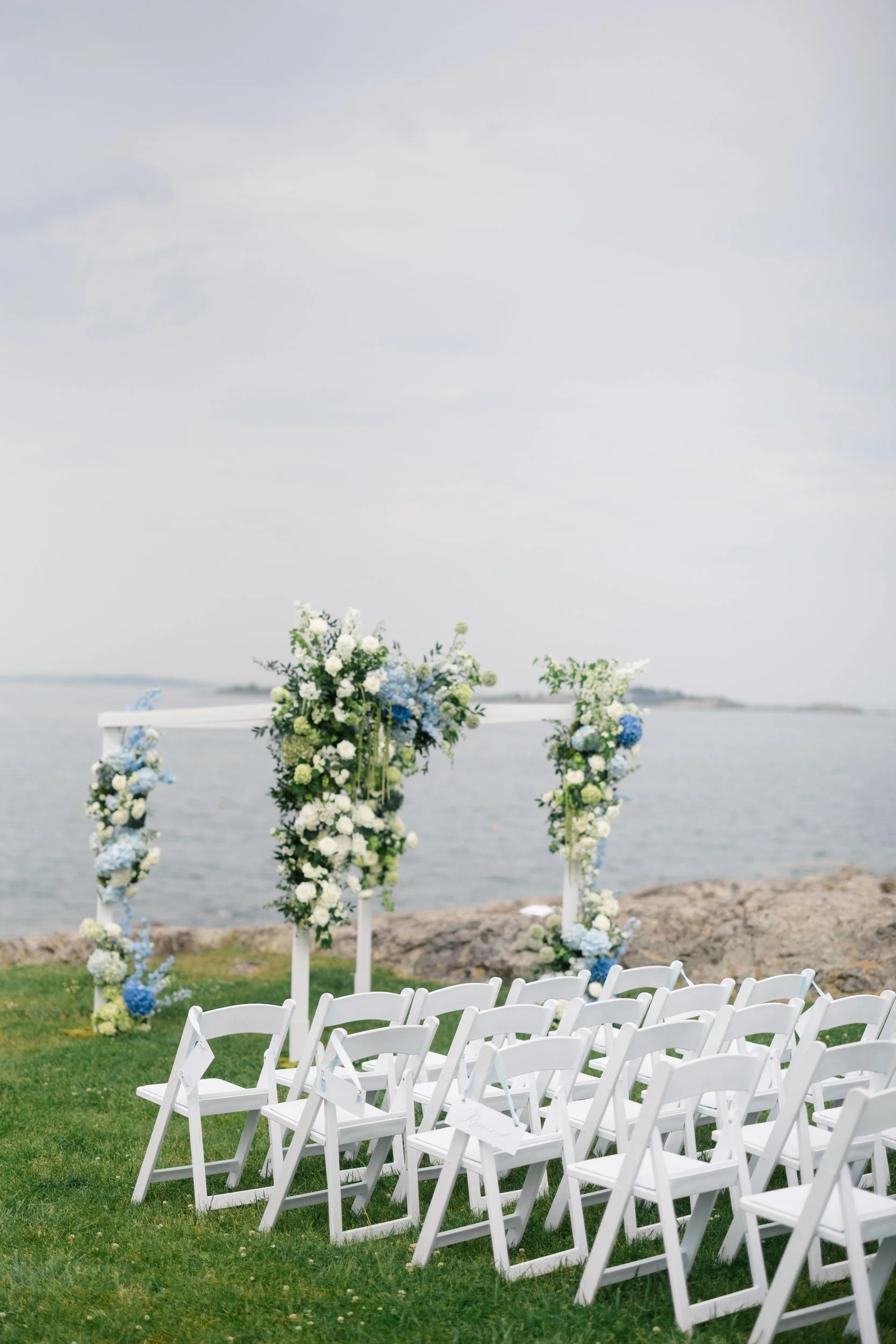 A modern chuppah installation with hanging amaranthus at a Marblehead Massachusetts waterfront wedding ceremony.