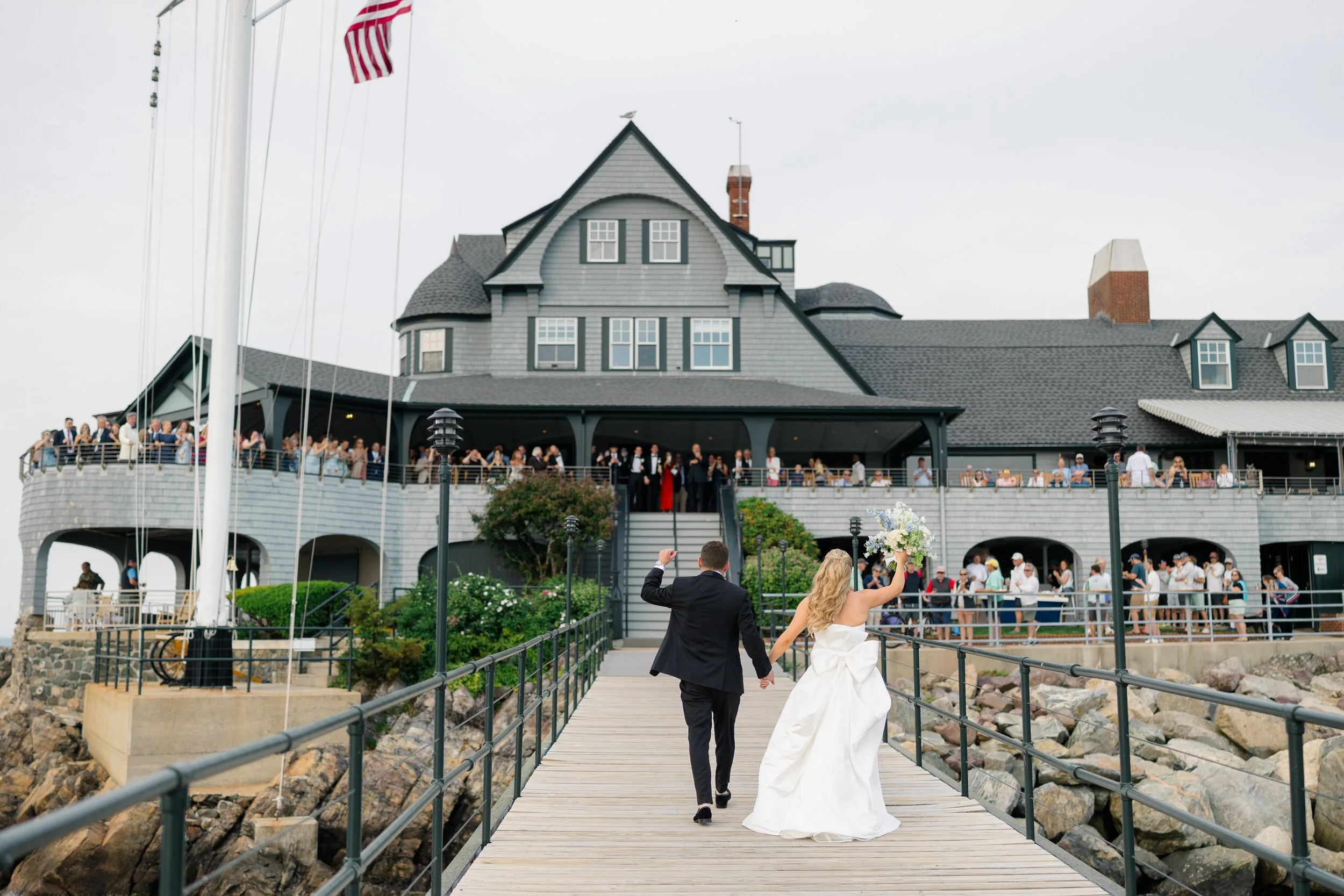 Cocktail hour overlooking Marblehead Harbor at Corinthian Yacht Club during a coastal wedding celebration.