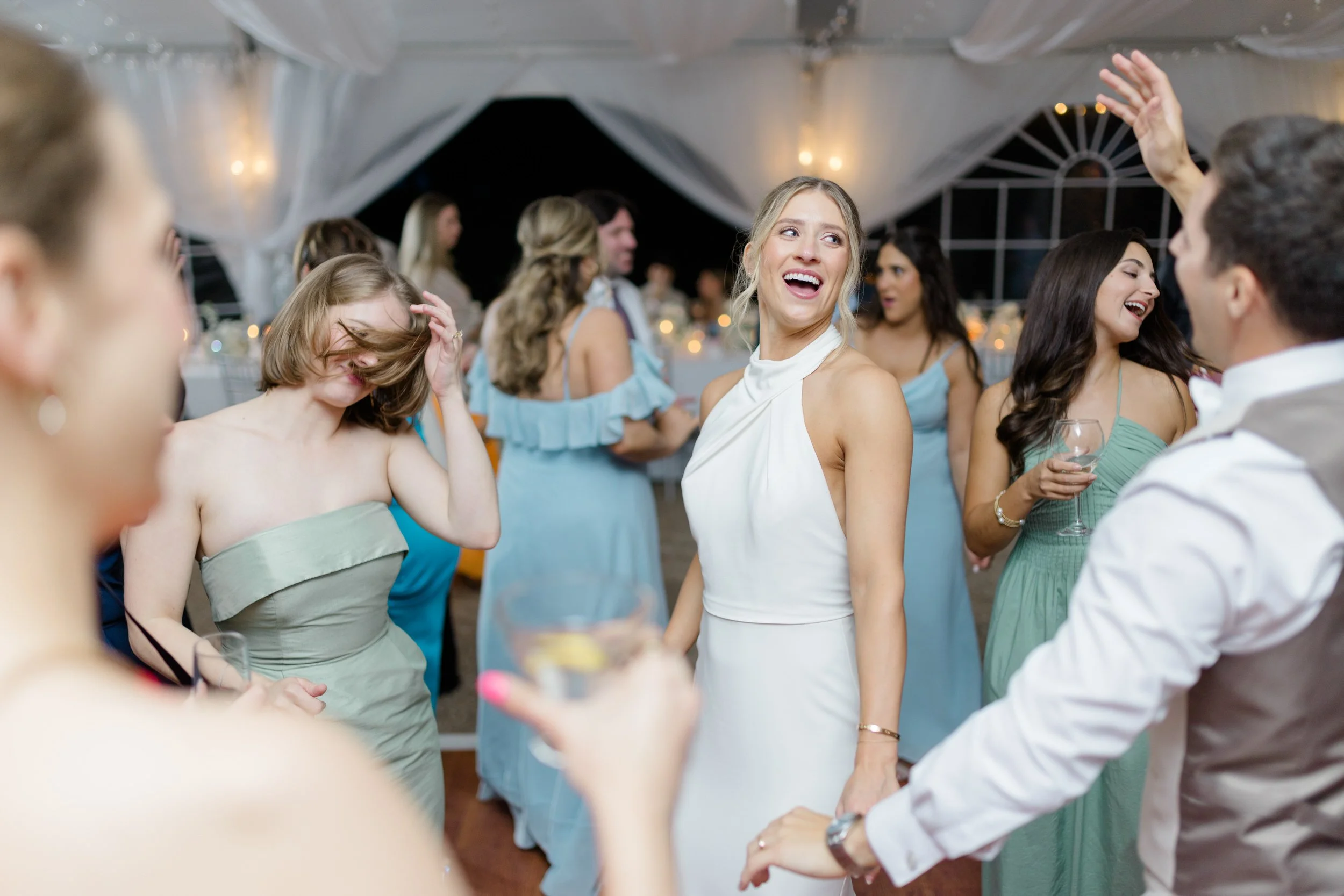 Guests celebrating on the dance floor during a summer wedding reception.